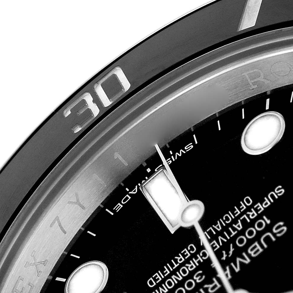 The image shows a close-up of the Rolex Submariner 114060 Men's Stainless Steel Black Dial's bezel and part of its dial, highlighting the minute markings and branding.