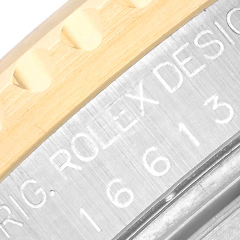 The image shows a close-up of the edge and part of the engraved case back on a Rolex Submariner 16613 Men's Steel and Gold (two tone) Silver Dial 16613 Men's Steel and Gold (two tone) Silver Dial watch.