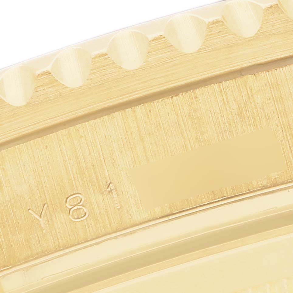 The image shows a close-up of the fluted bezel and serial number engraving of a Rolex Submariner 16618 Men's Yellow Gold Blue Dial 16618 Men's Yellow Gold Blue Dial watch.