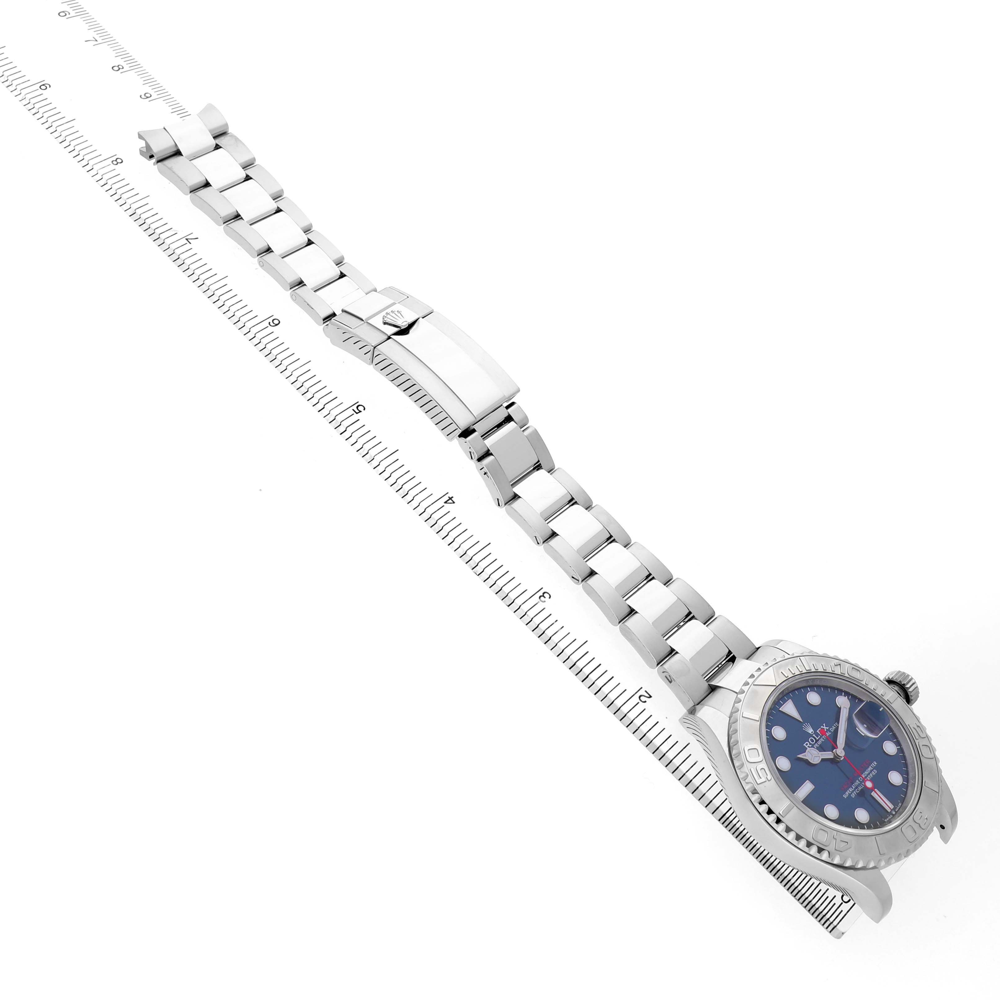 The Rolex Yacht-Master 126622 Men's Stainless Steel Blue Dial watch is displayed diagonally, highlighting its bracelet, clasp, and blue dial, with a ruler in the background.