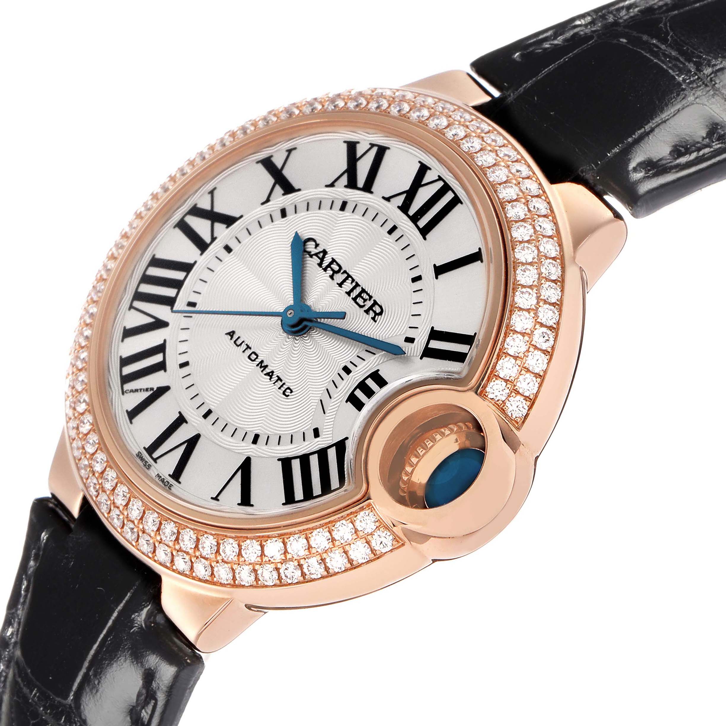 The Cartier Ballon Bleu WE902066 Women's Rose Gold Silver Dial watch is shown from a top angle, highlighting its diamond-studded bezel and black leather strap.