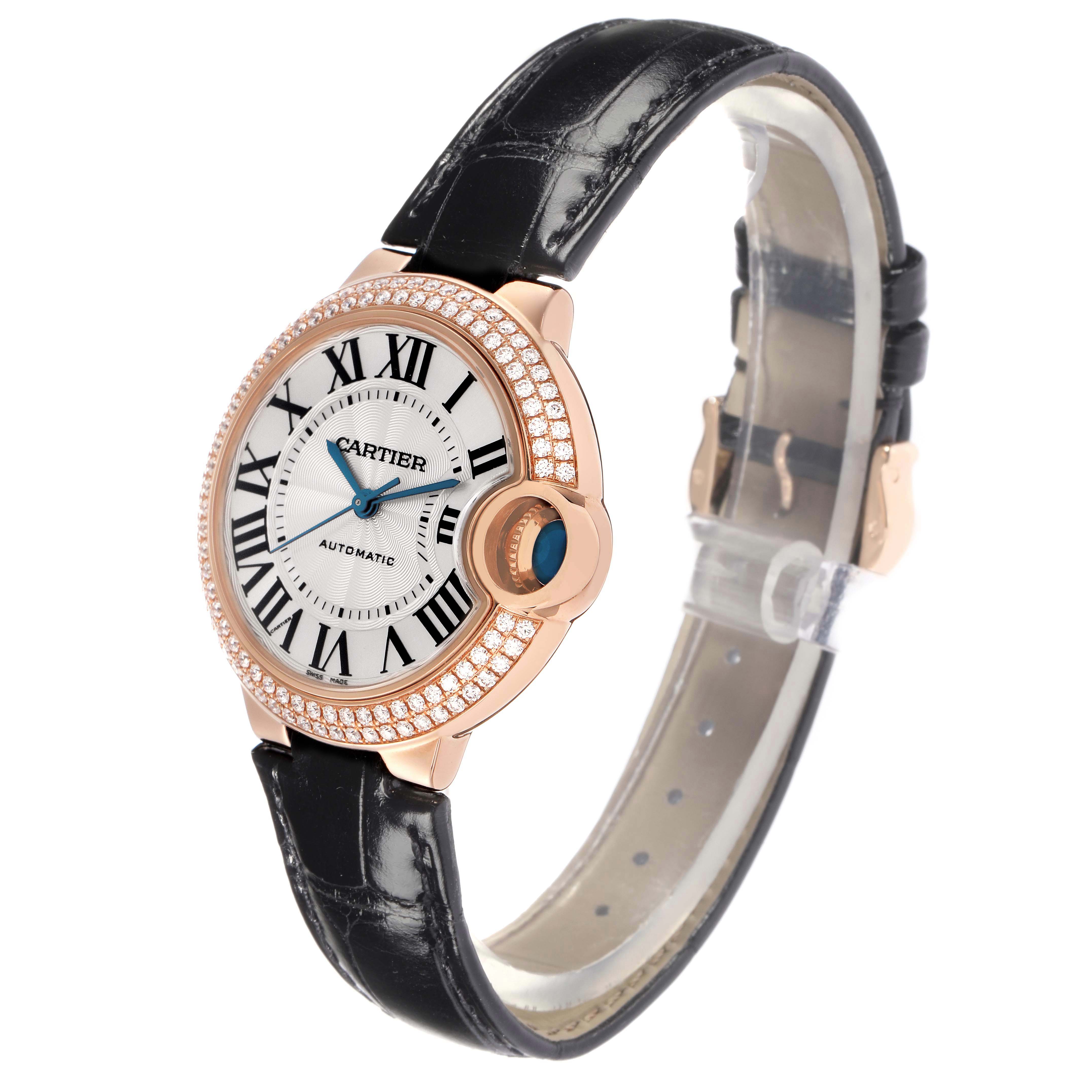 The Cartier Ballon Bleu WE902066 Women's Rose Gold Silver Dial watch is shown at a slight angle, highlighting its round face, Roman numerals, diamond bezel, and leather strap.