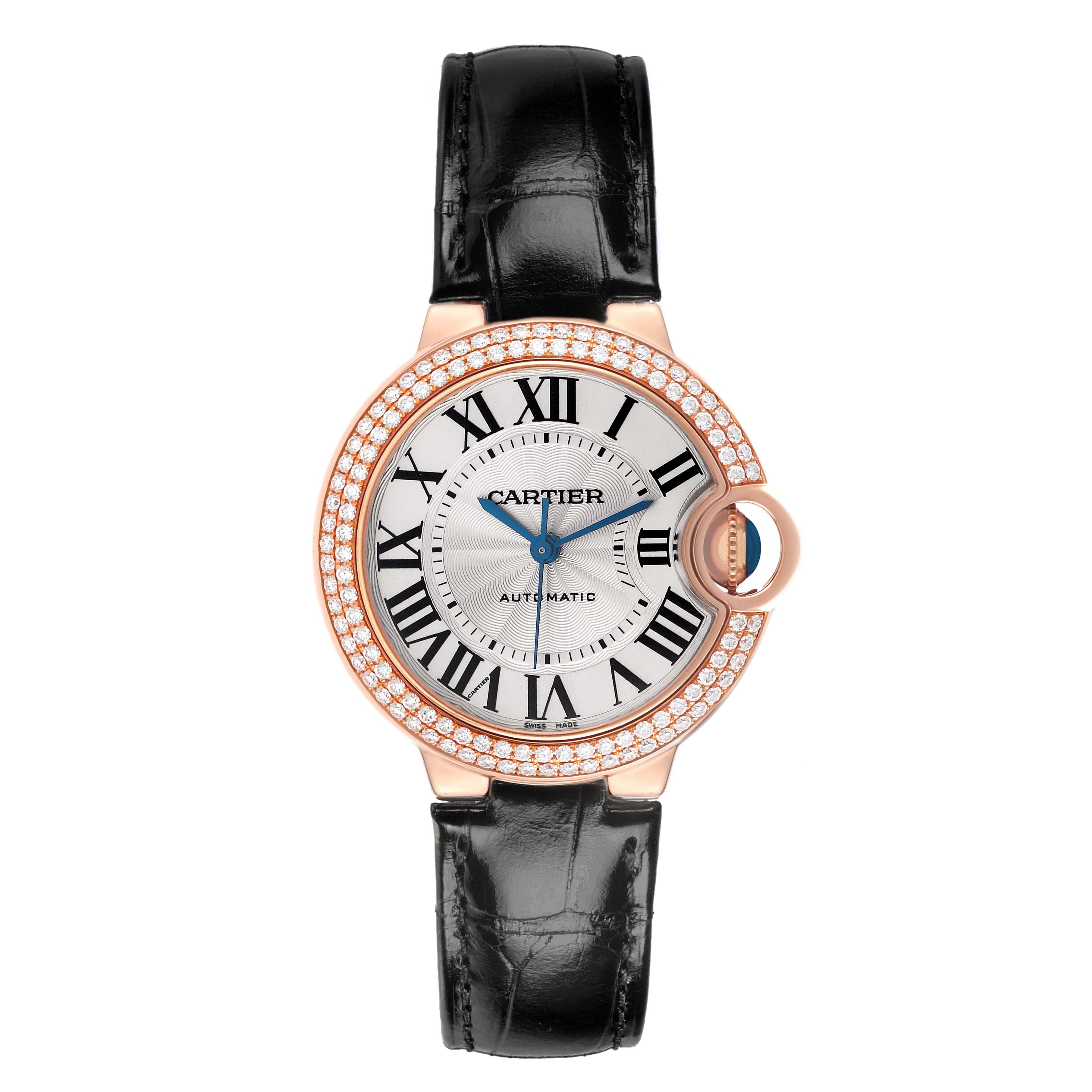 The Cartier Ballon Bleu WE902066 Women
s Rose Gold Silver Dial WE902066 Women
s Rose Gold Silver Dial watch is shown from a front angle, displaying its face, Roman numerals, blue hands, diamond bezel, and black strap.