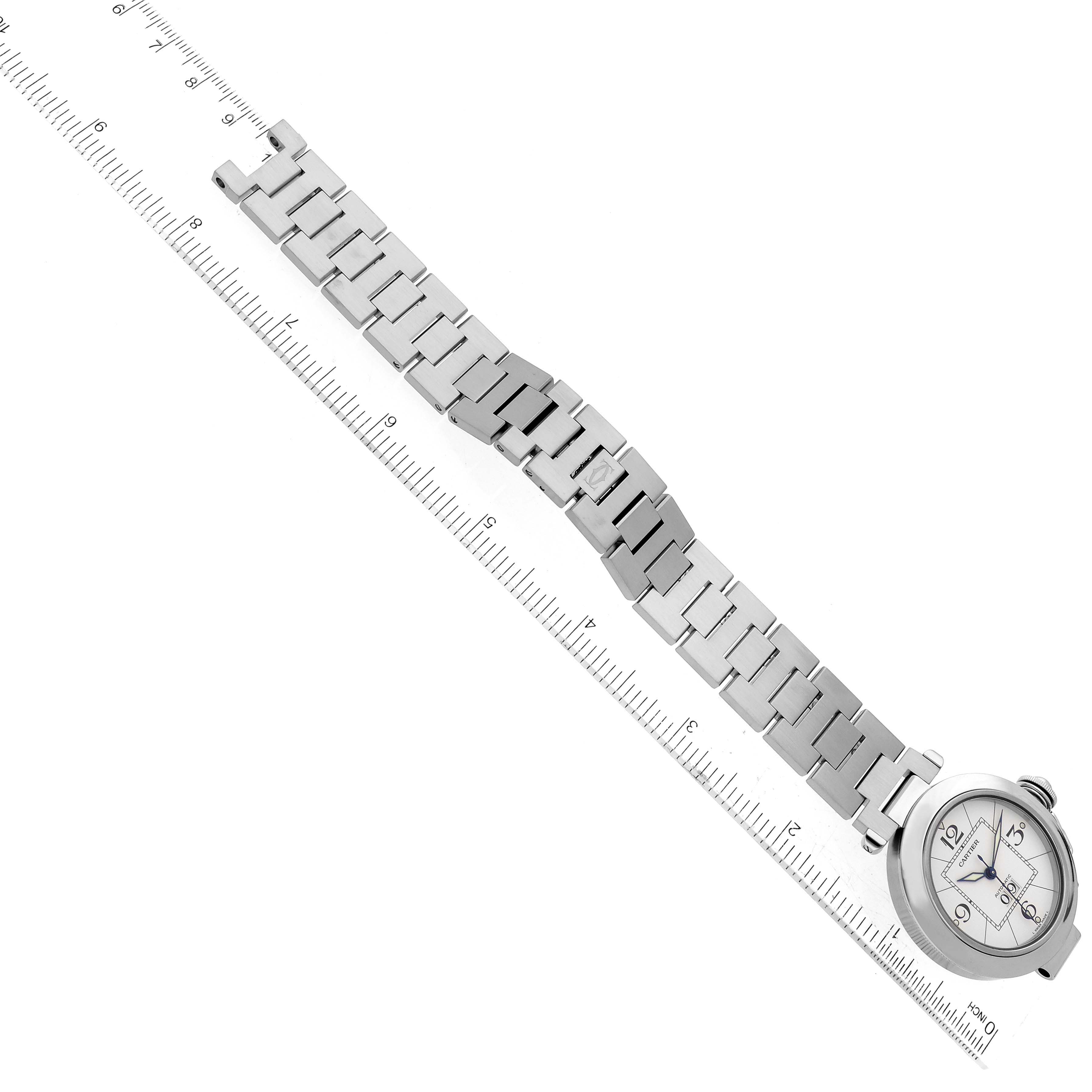 The image shows a Cartier Pasha W31055M7 Men's Stainless Steel Silver Dial W31055M7 Men's Stainless Steel Silver Dial watch laid flat with its metal bracelet fully extended next to a measuring ruler.