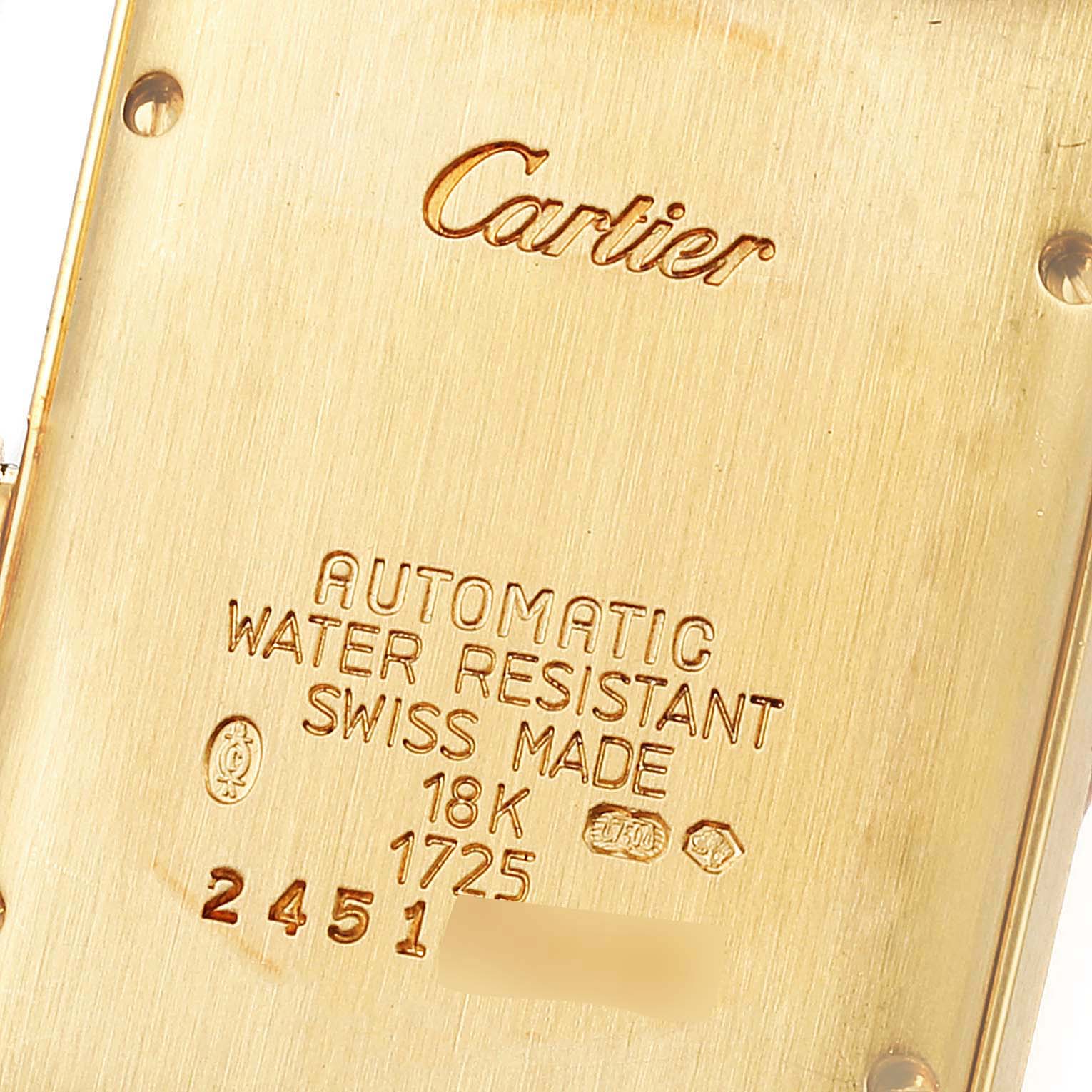 The image shows the back case of a Cartier Tank Americaine W26035K2 Women's Yellow Gold Silver Dial W26035K2 Women's Yellow Gold Silver Dial watch with engravings indicating specifications and serial numbers.
