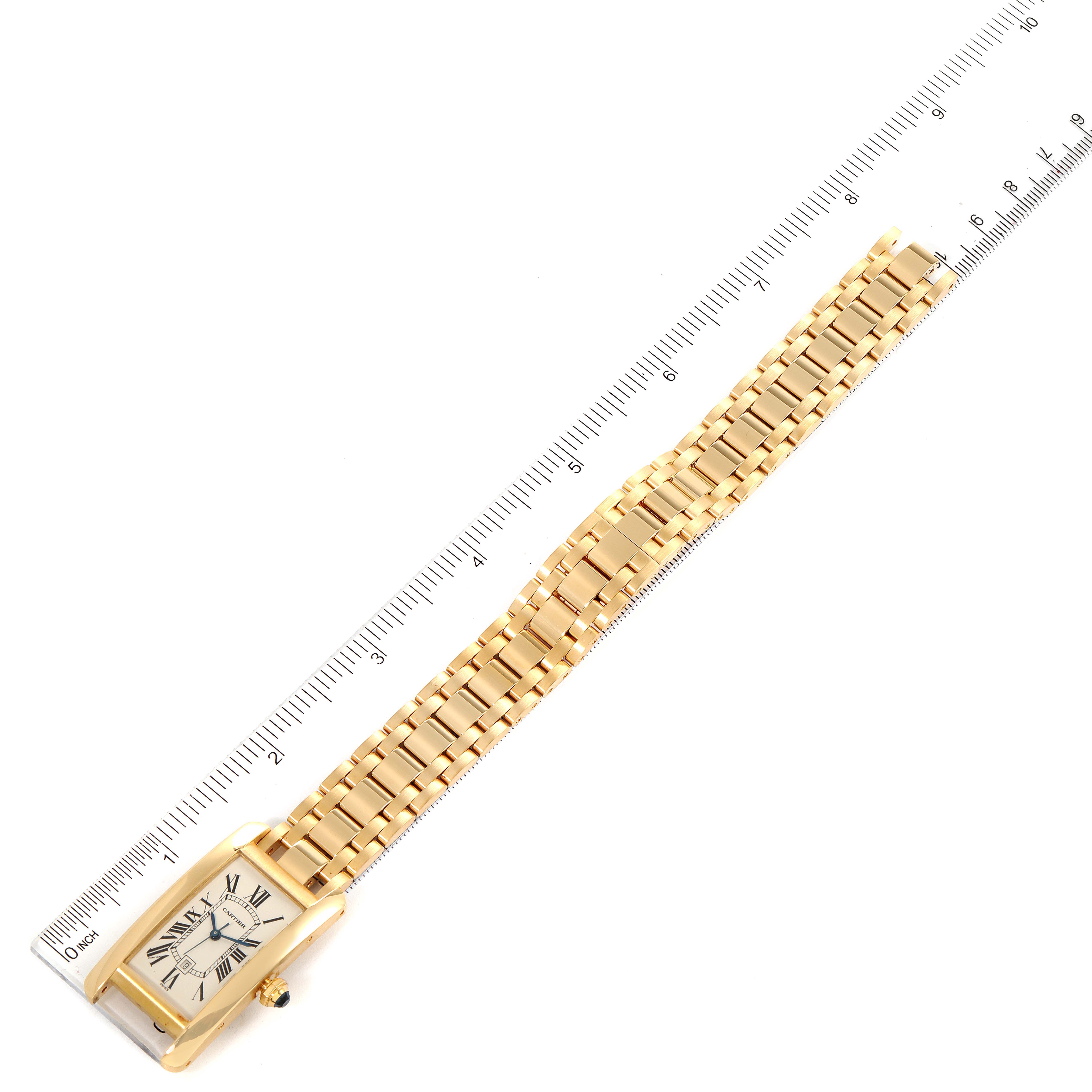 The image shows a gold Cartier Tank Americaine W26035K2 Women's Yellow Gold Silver Dial W26035K2 Women's Yellow Gold Silver Dial watch laid flat with its bracelet extended and a ruler beside it for scale.