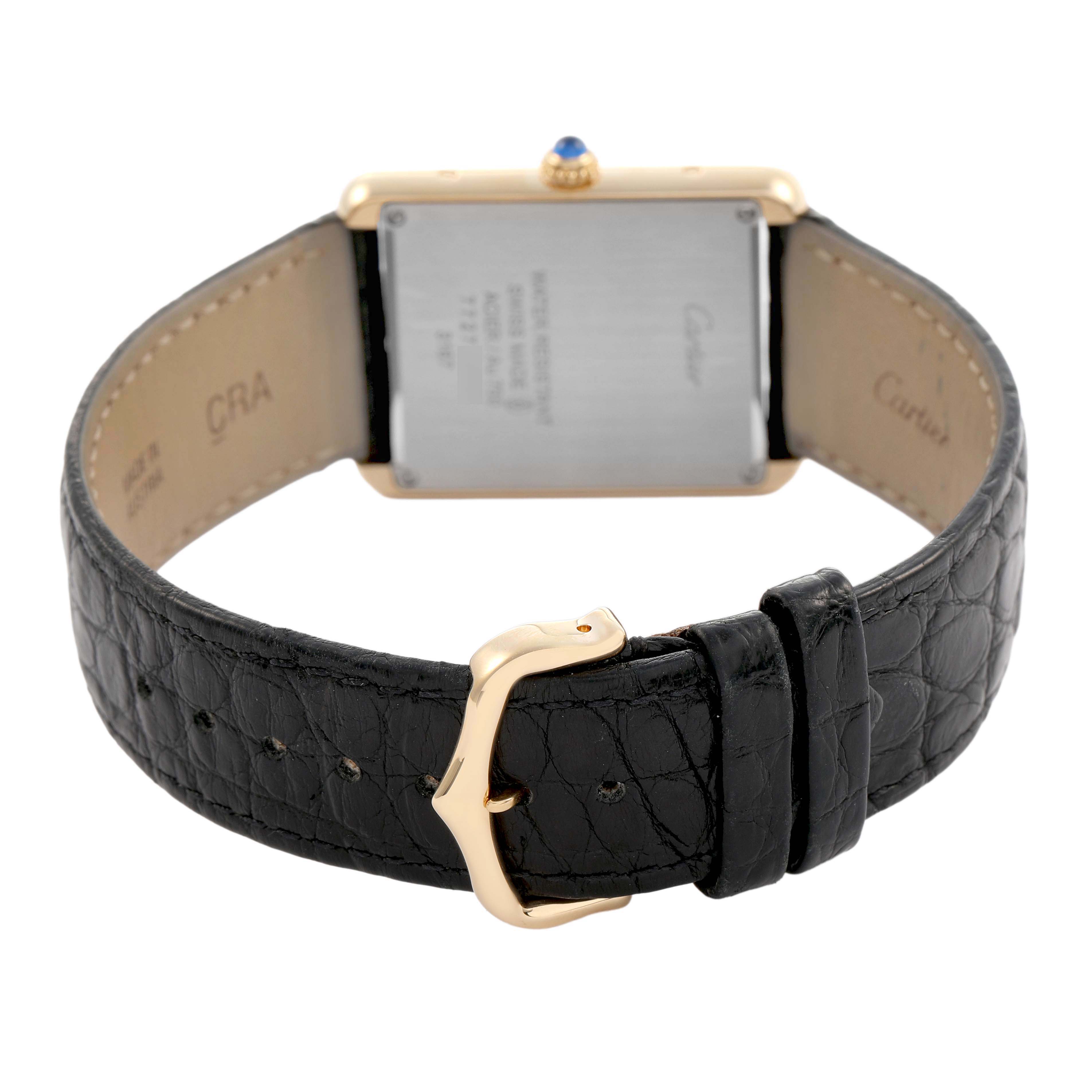 The Cartier Tank Solo W5200004 Men's Yellow Gold Silver Dial watch is shown from the back, displaying the case back, leather strap, and gold buckle.