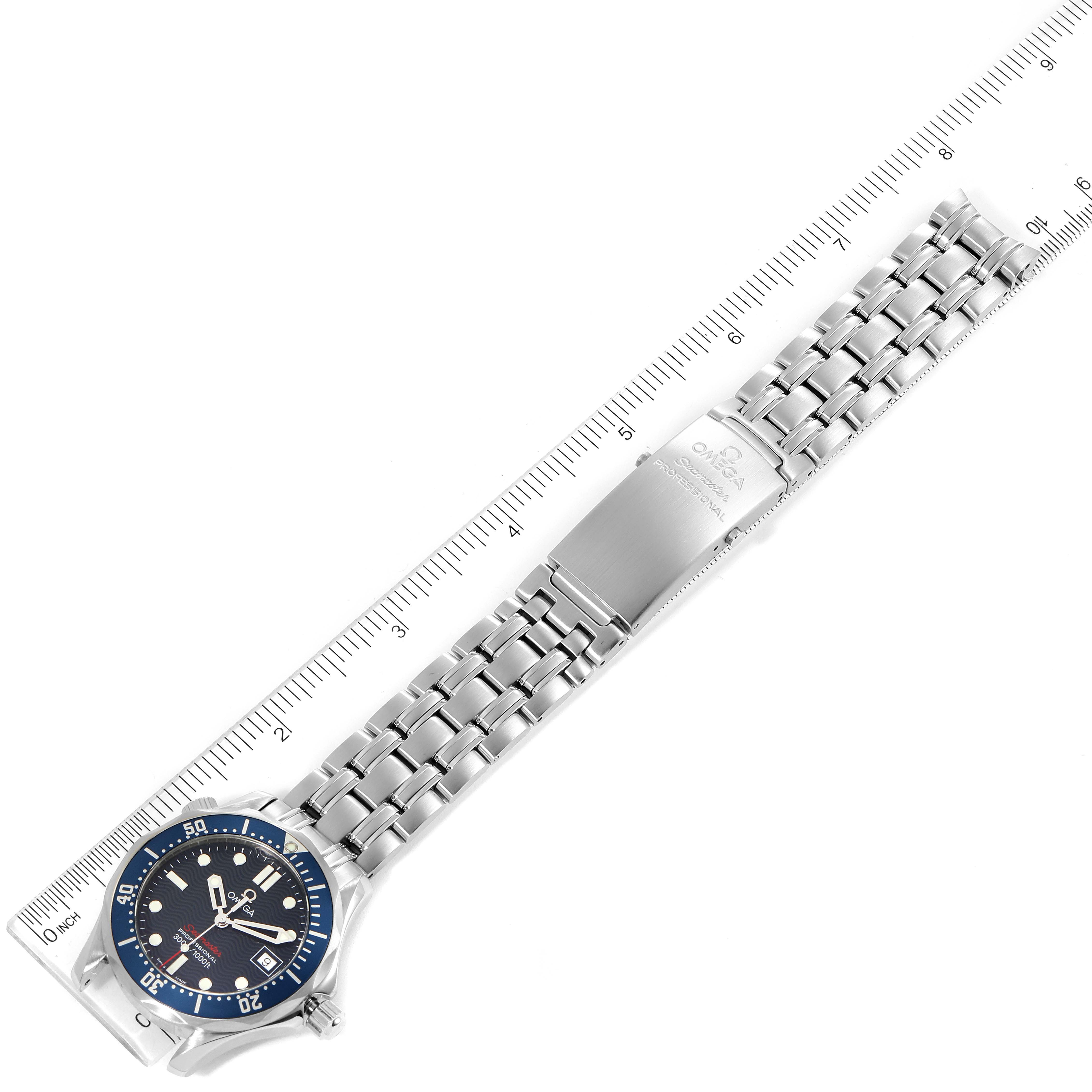 This image shows an Omega Seamaster 2223.80.00 Men's Stainless Steel Blue Dial 2223.80.00 Men's Stainless Steel Blue Dial watch from a top-down angle, displaying its face, bezel, metal bracelet, and clasp against a ruler for scale.