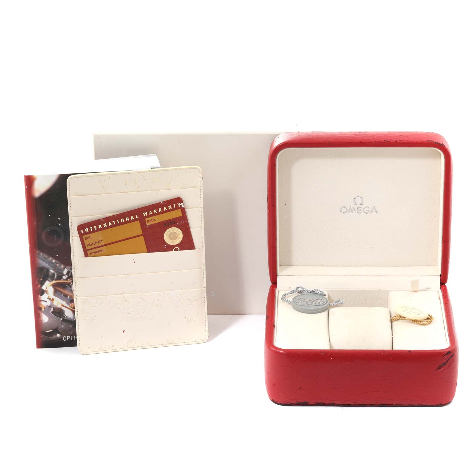 The image shows the accessories for the Omega Aqua Terra 2503.33.00 Men
s Stainless Steel Silver Dial 2503.33.00 Men
s Stainless Steel Silver Dial watch, including the box, international warranty card, and tags.