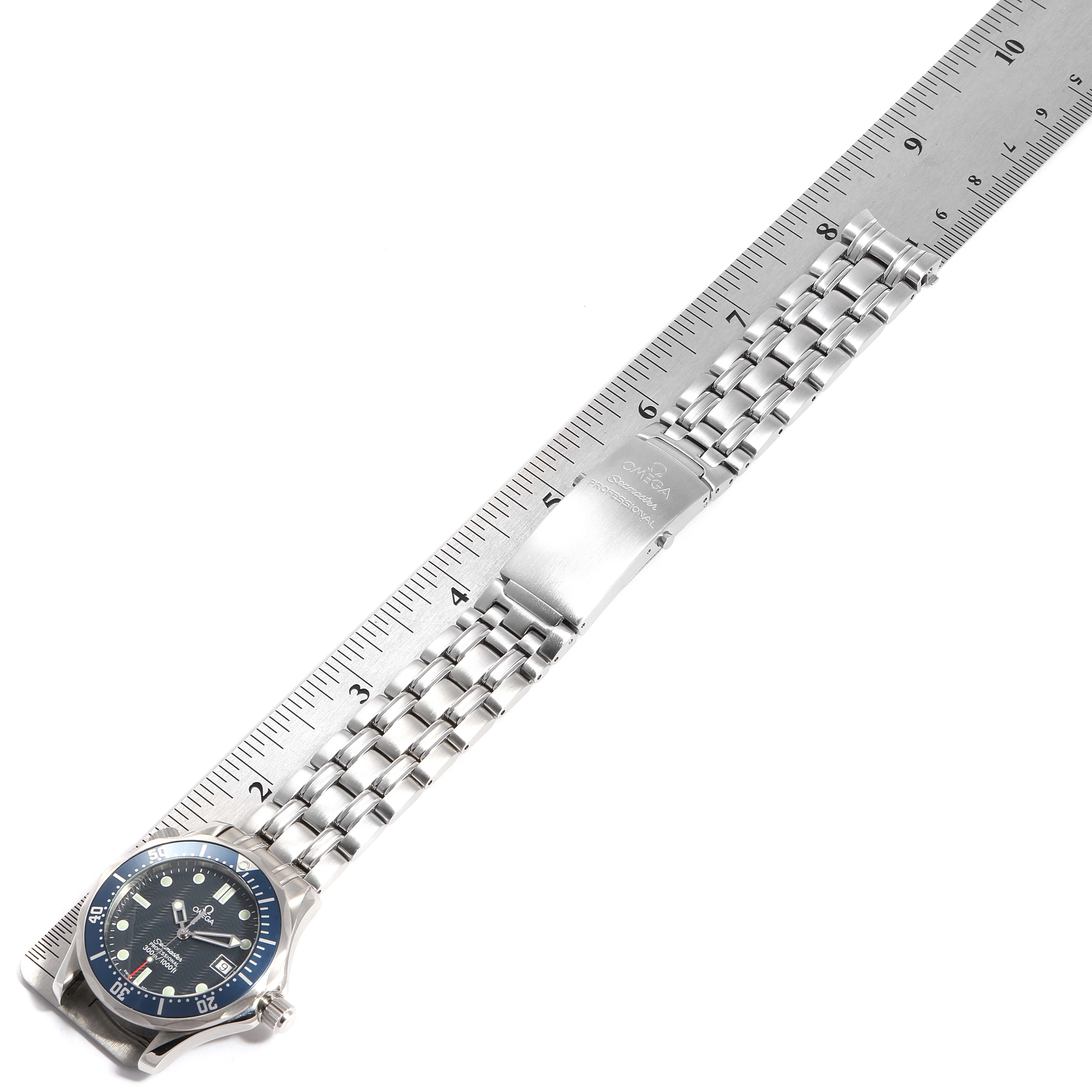 The image shows an Omega Seamaster 2561.80.00 Men
s Stainless Steel Blue Dial 2561.80.00 Men
s Stainless Steel Blue Dial watch laid flat next to a ruler, showcasing the watch face and metal bracelet.