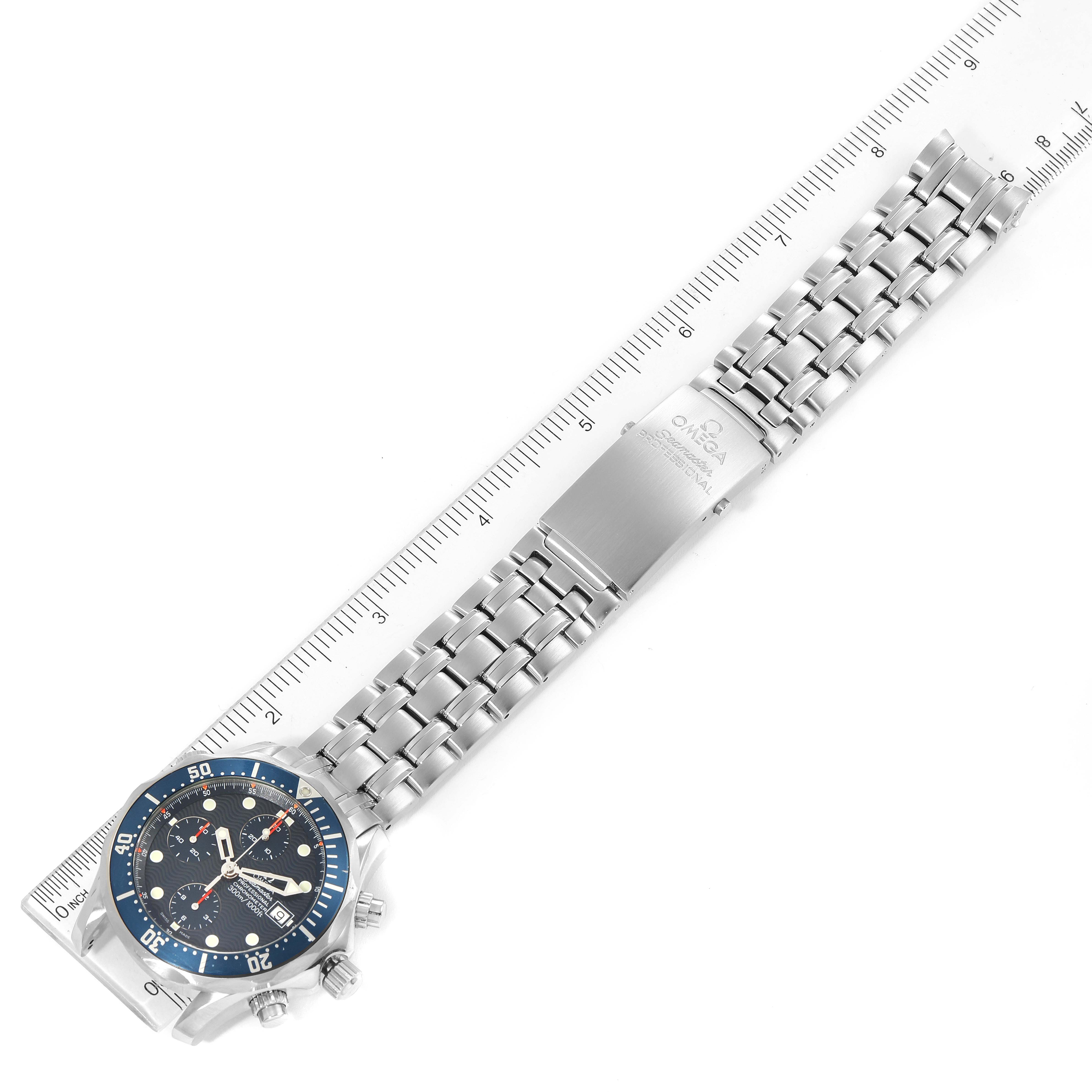 The image shows an Omega Seamaster 2599.80.00 Men
s Stainless Steel Blue Dial 2599.80.00 Men
s Stainless Steel Blue Dial watch with its bracelet extended alongside a ruler for scale.