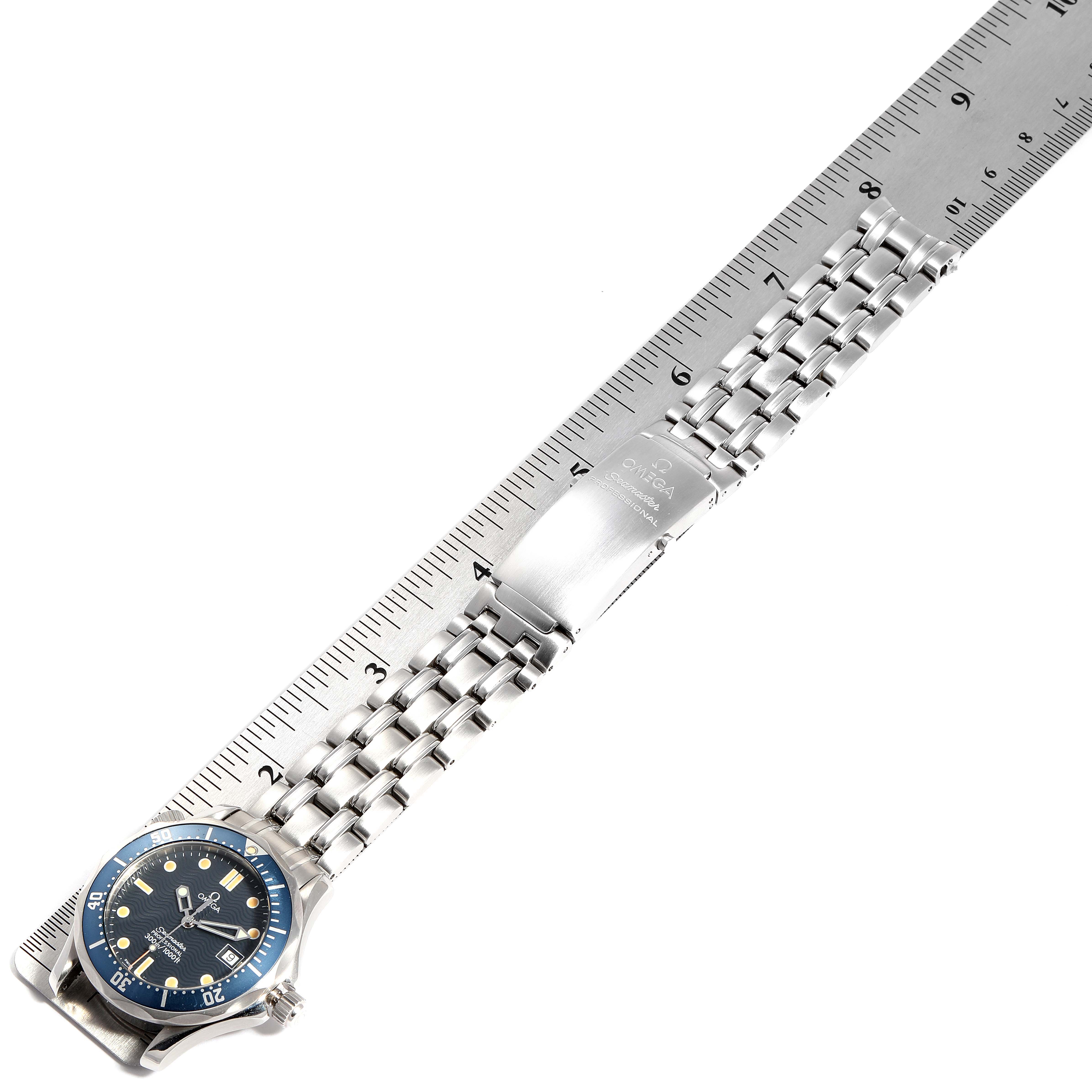 The image shows an Omega Seamaster 2561.80.00 Men
s Stainless Steel Blue Dial 2561.80.00 Men
s Stainless Steel Blue Dial watch laid flat next to a ruler, displaying the watch face, bezel, and stainless steel bracelet.