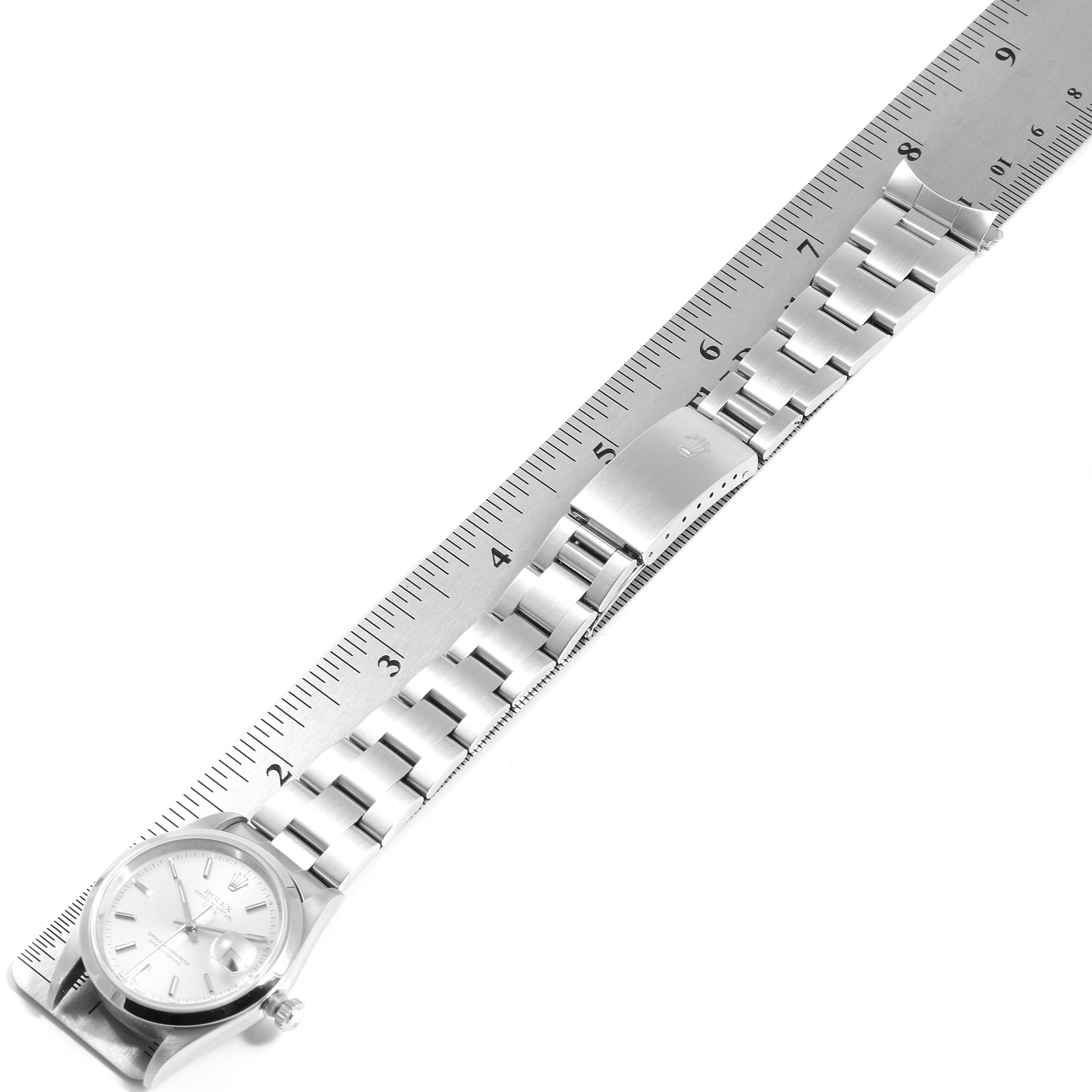 The Rolex Date 15200 Men's Stainless Steel Silver Dial 15200 Men's Stainless Steel Silver Dial watch is shown from above, displaying its full bracelet and part of a ruler for scale.