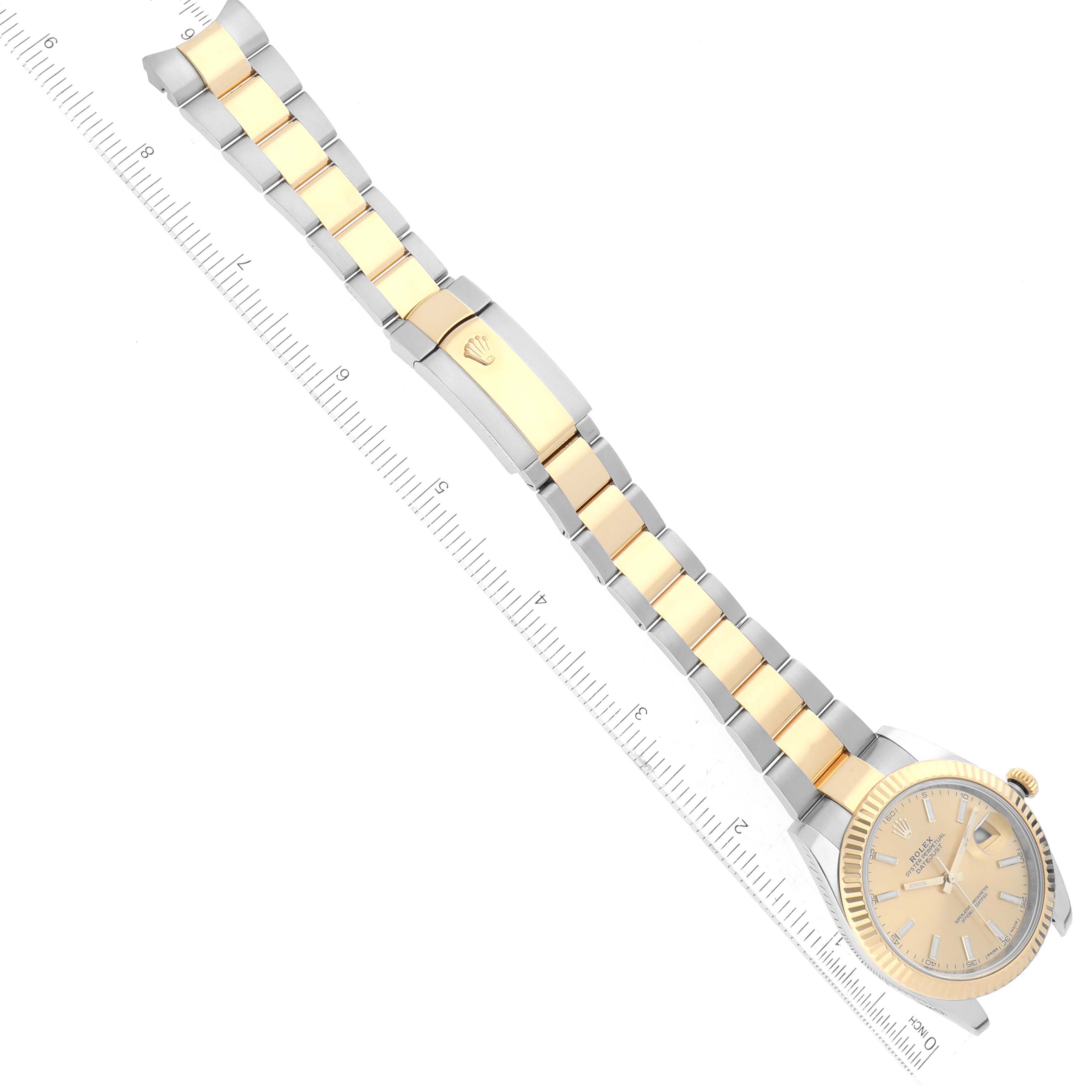 The image shows a top-down view of a Rolex Datejust 41 126333 Men's Steel and Gold (two tone) Champagne Dial 126333 Men's Steel and Gold (two tone) Champagne Dial watch, highlighting its face, band, and clasp next to a ruler.