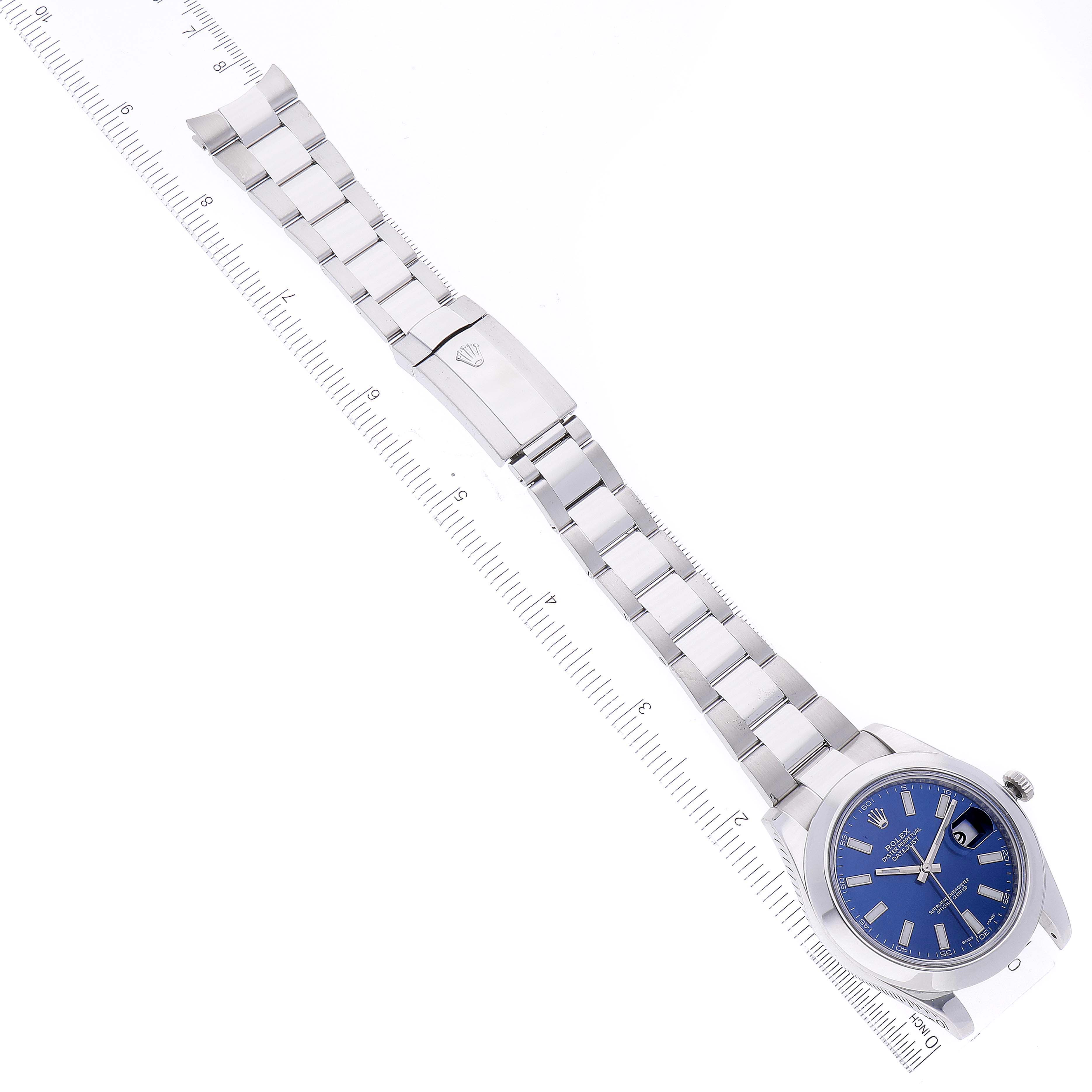 The image shows a full view of the Rolex Datejust 41 116300 Men's Stainless Steel Blue Dial 116300 Men's Stainless Steel Blue Dial watch, including its bracelet, face, and clasp, placed next to a ruler for scale.