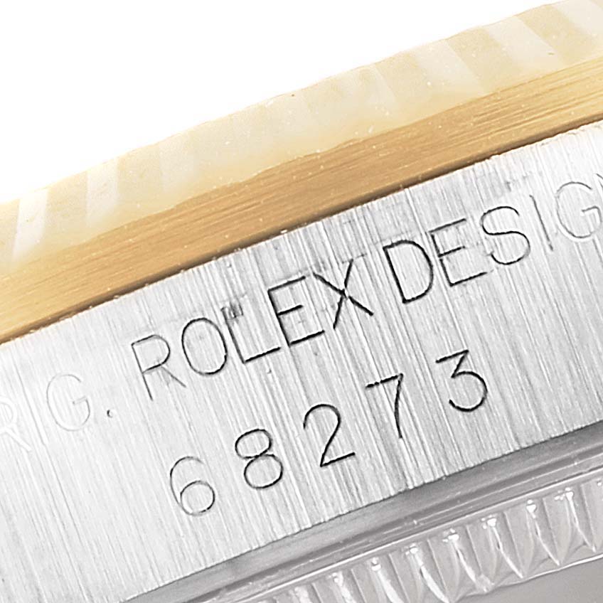 The image shows a close-up of the case side engraving and bezel of a Rolex Mid-Size 68273 Women
s Steel and Gold (two tone) White Dial 68273 Women
s Steel and Gold (two tone) White Dial model 68273.