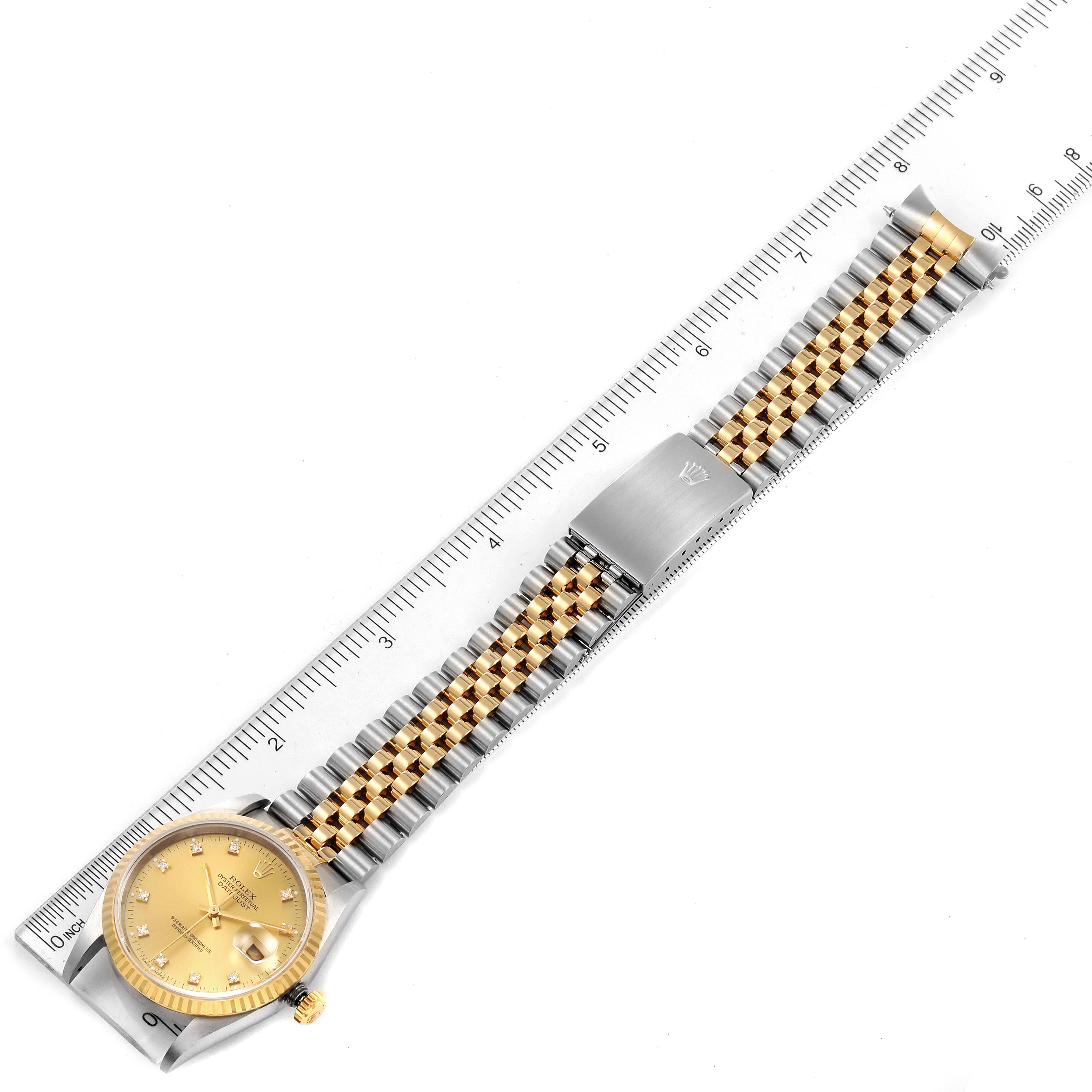 This image shows a Rolex Datejust 16233 Men's Steel and Gold (two tone) Champagne Dial 16233 Men's Steel and Gold (two tone) Champagne Dial watch laid flat with its bracelet extended, positioned on a ruler for measurement.