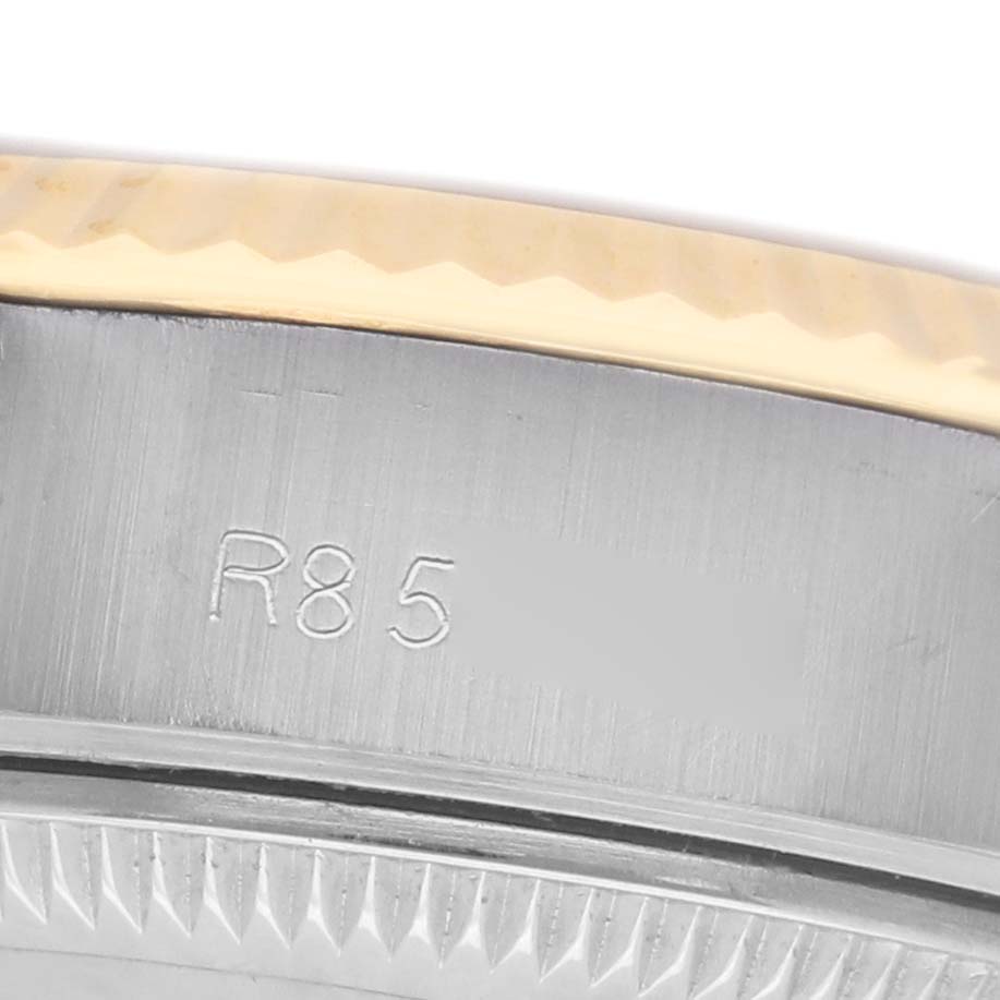 The image shows a close-up of the Rolex Datejust 69173 Women's Steel and Gold (two tone) Champagne Dial watch's bezel and engraved edge, highlighting the metal texture and detail.