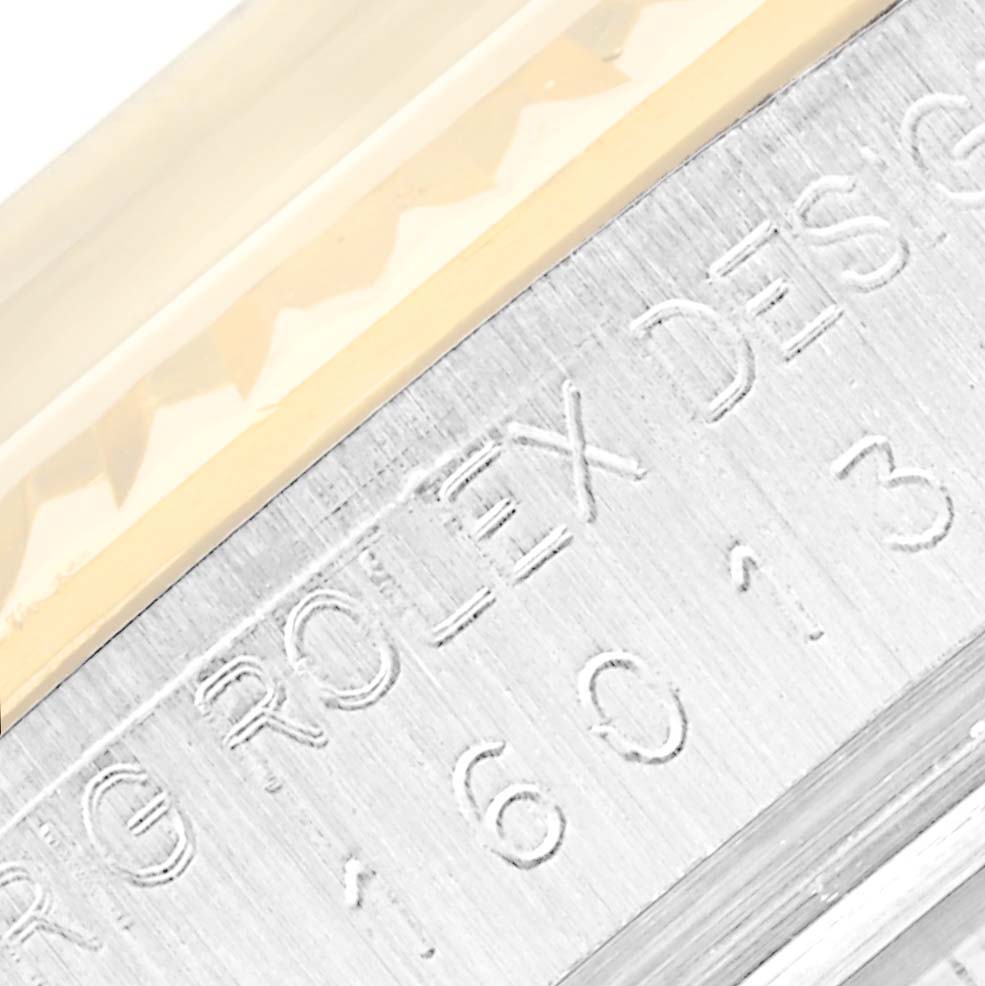 This image shows an angled close-up of the casing and bezel of a Vintage Collection Rolex watch, displaying engraved details.