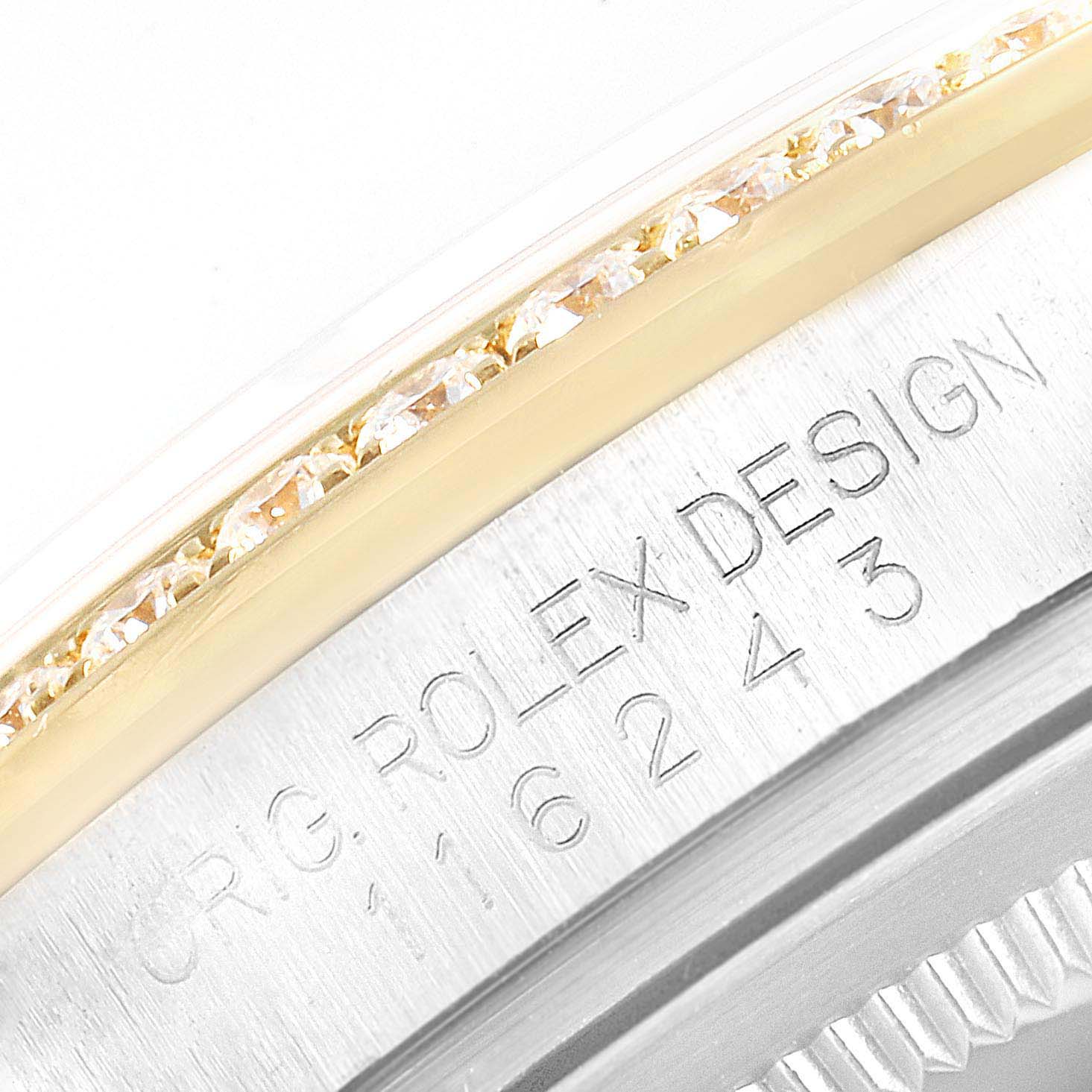 The image shows a close-up of a Rolex Datejust 116243 Men's Steel and Gold (two tone) Black Dial's bezel and engraved model number.