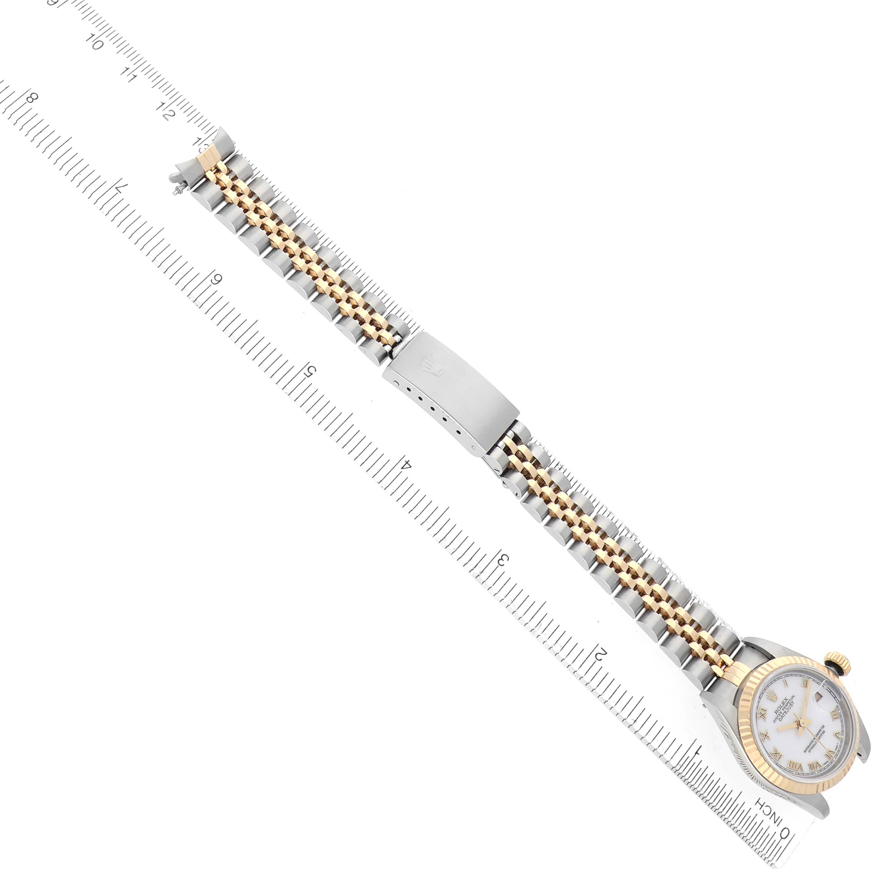 The image shows a top view of a Rolex Datejust 79173 Women's Steel and Gold (two tone) White Dial 79173 Women's Steel and Gold (two tone) White Dial watch, highlighting the bracelet, clasp, and bezel against a ruler for scale.