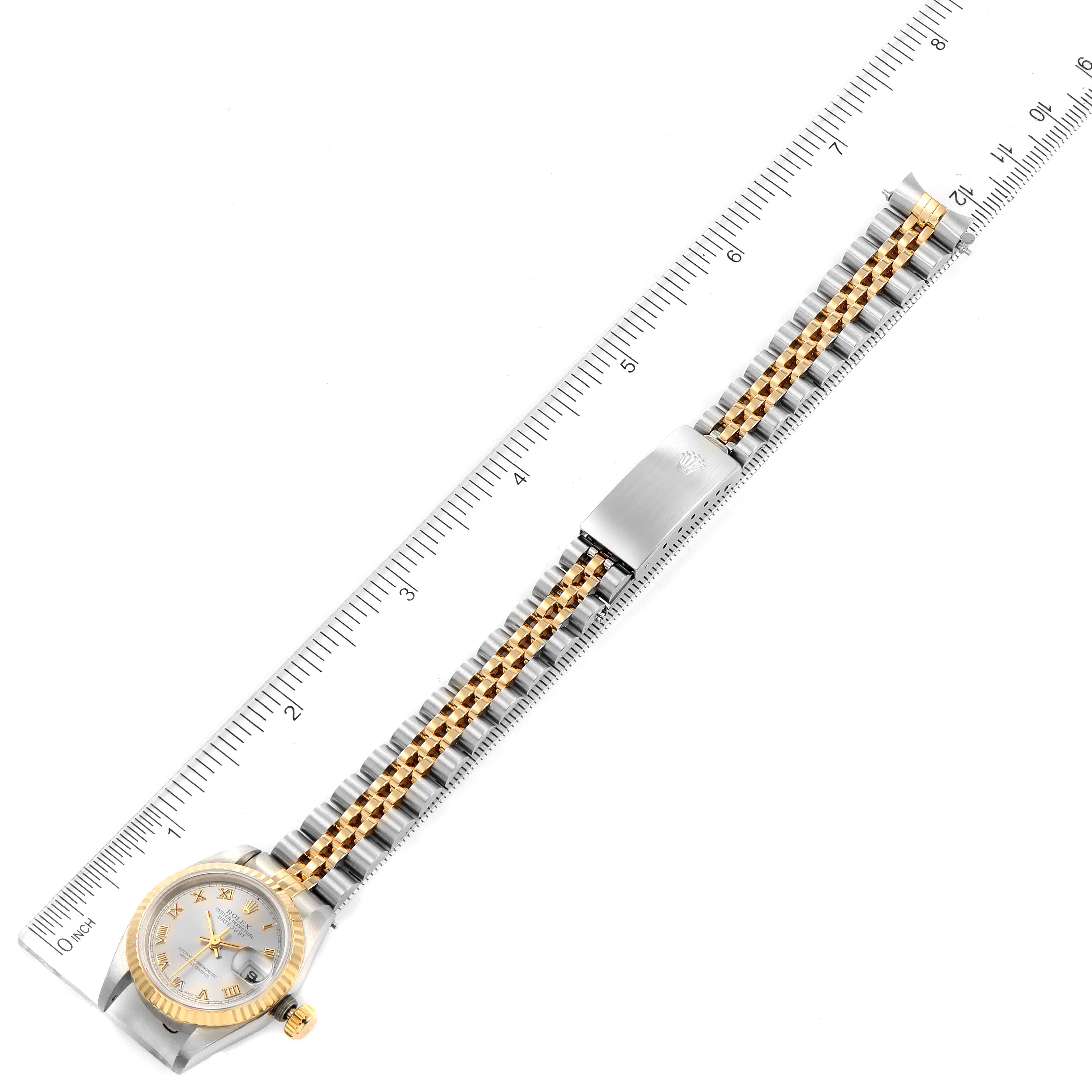 The image shows a top view of a Rolex Datejust 69173 Women
s Steel and Gold (two tone) Silver Dial 69173 Women
s Steel and Gold (two tone) Silver Dial watch with its band aligned along a ruler.