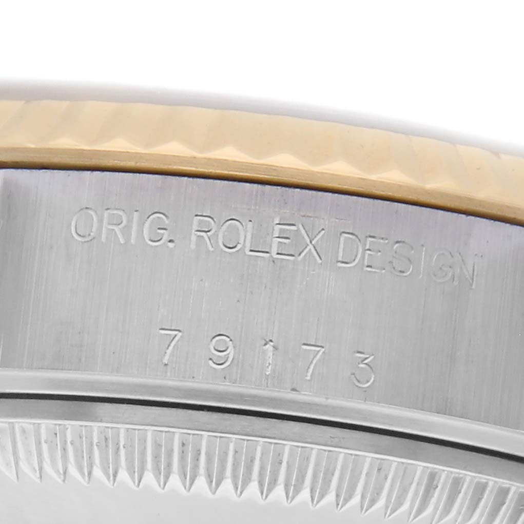 The image shows a close-up of the case side of a Rolex Datejust 79173 Women's Steel and Gold (two tone) Silver Dial 79173 Women's Steel and Gold (two tone) Silver Dial watch, highlighting the engraved model number and design details.