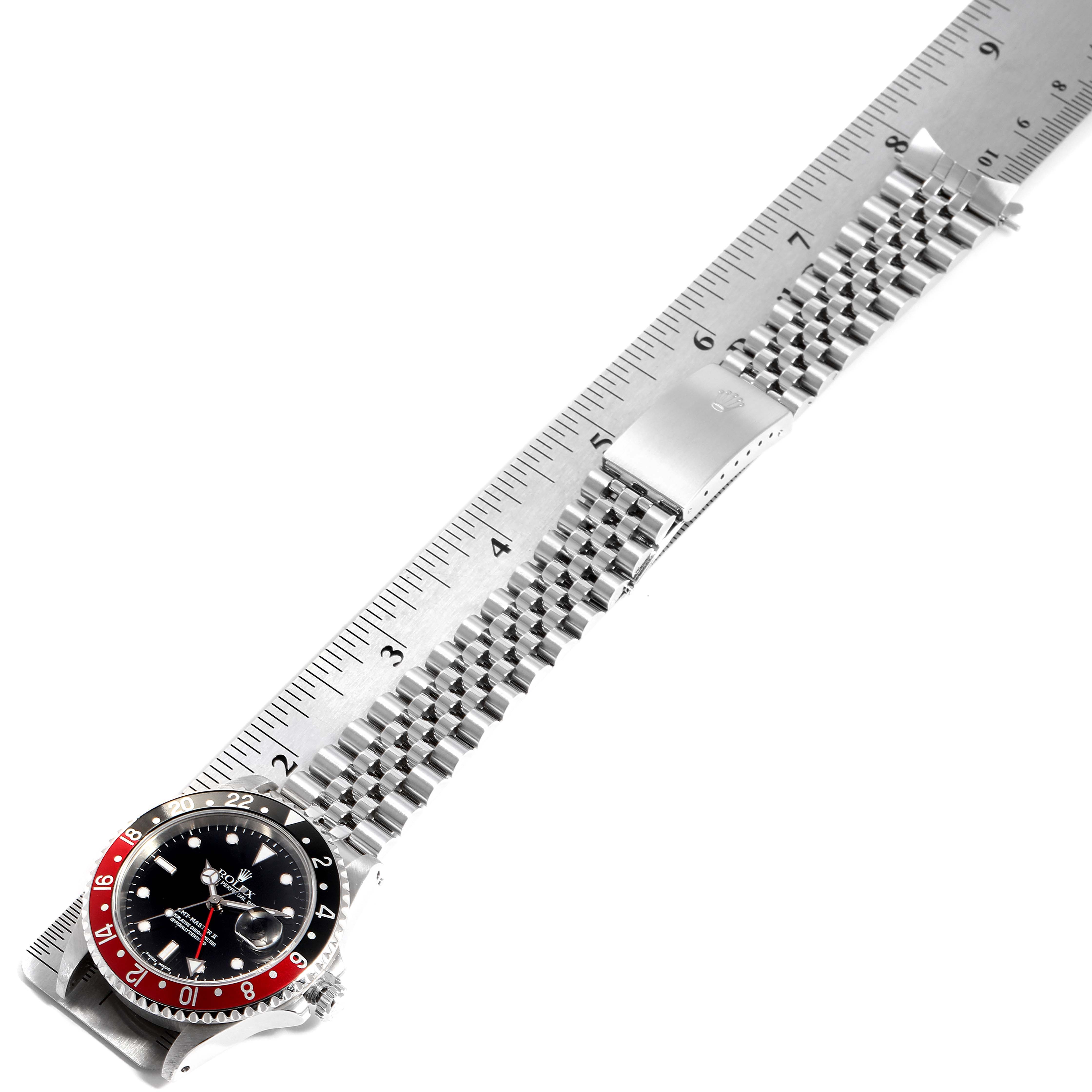 The image shows a top view of a Rolex GMT-Master 16710 Men's Stainless Steel Black Dial 16710 Men's Stainless Steel Black Dial watch placed alongside a ruler, highlighting its bezel, dial, and bracelet.