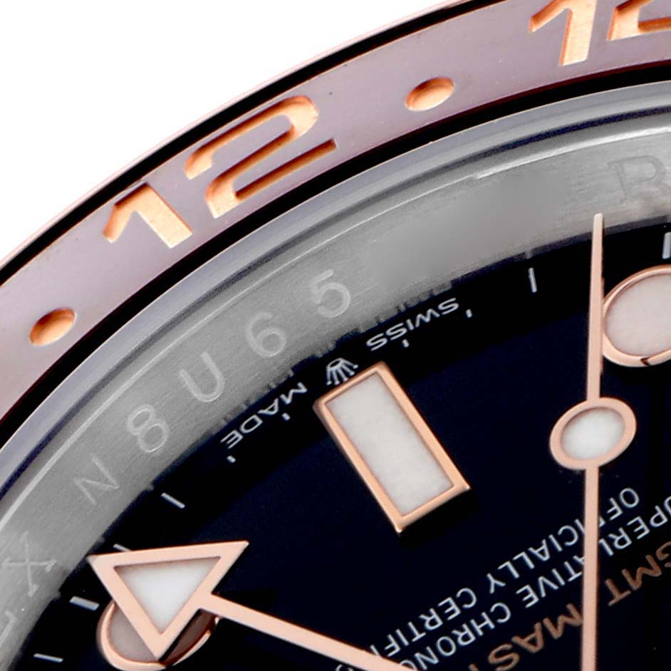 The close-up angle shows the bezel, dial, and hands of the Rolex GMT-Master 126711CHNR Men's Steel and Gold (two tone) Black Dial watch, highlighting the 12-hour mark.