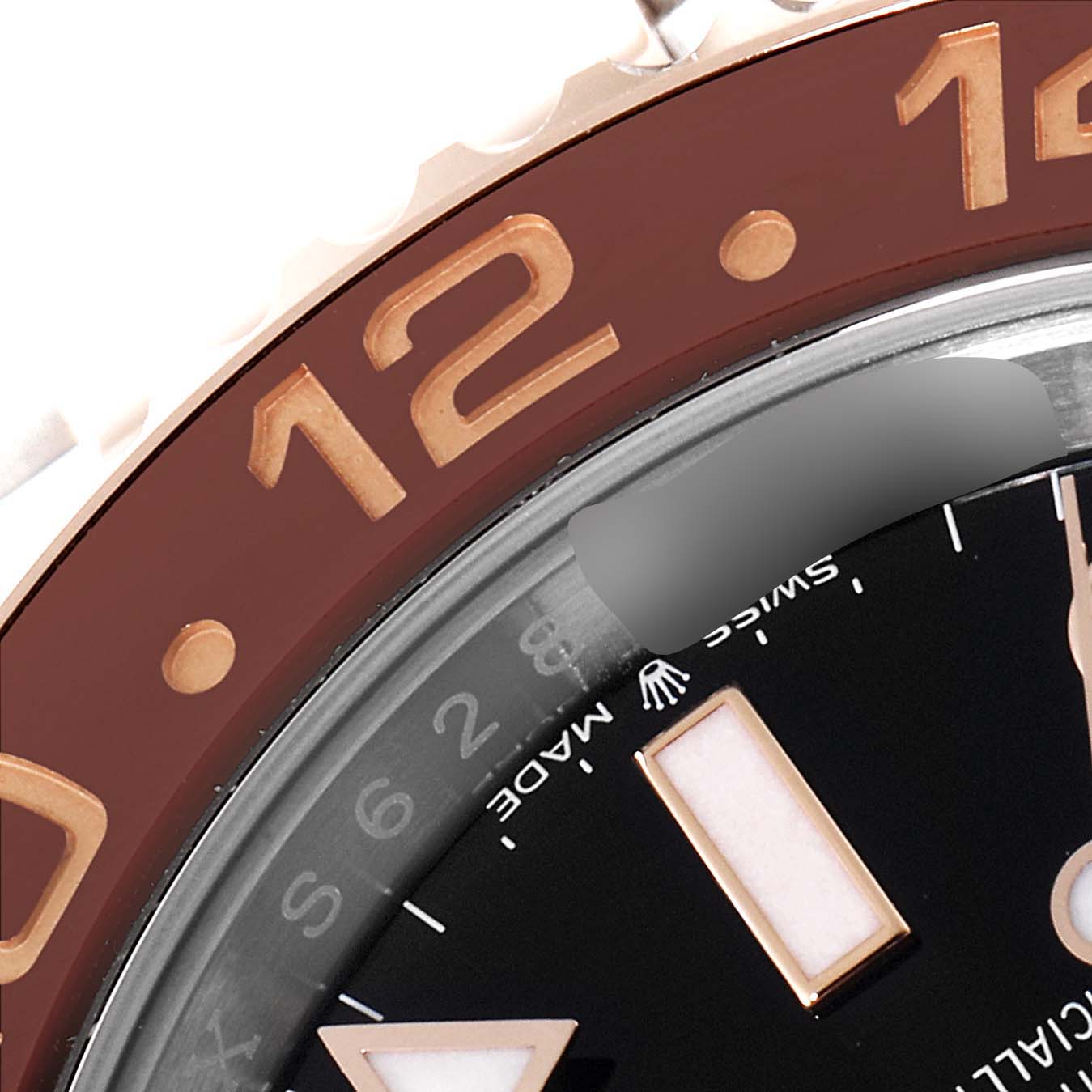 The image shows a close-up of the bezel and part of the dial of a Rolex GMT-Master 126711 Men's Steel and Gold (two tone) Black Dial 126711 Men's Steel and Gold (two tone) Black Dial watch at the 12 o'clock position.