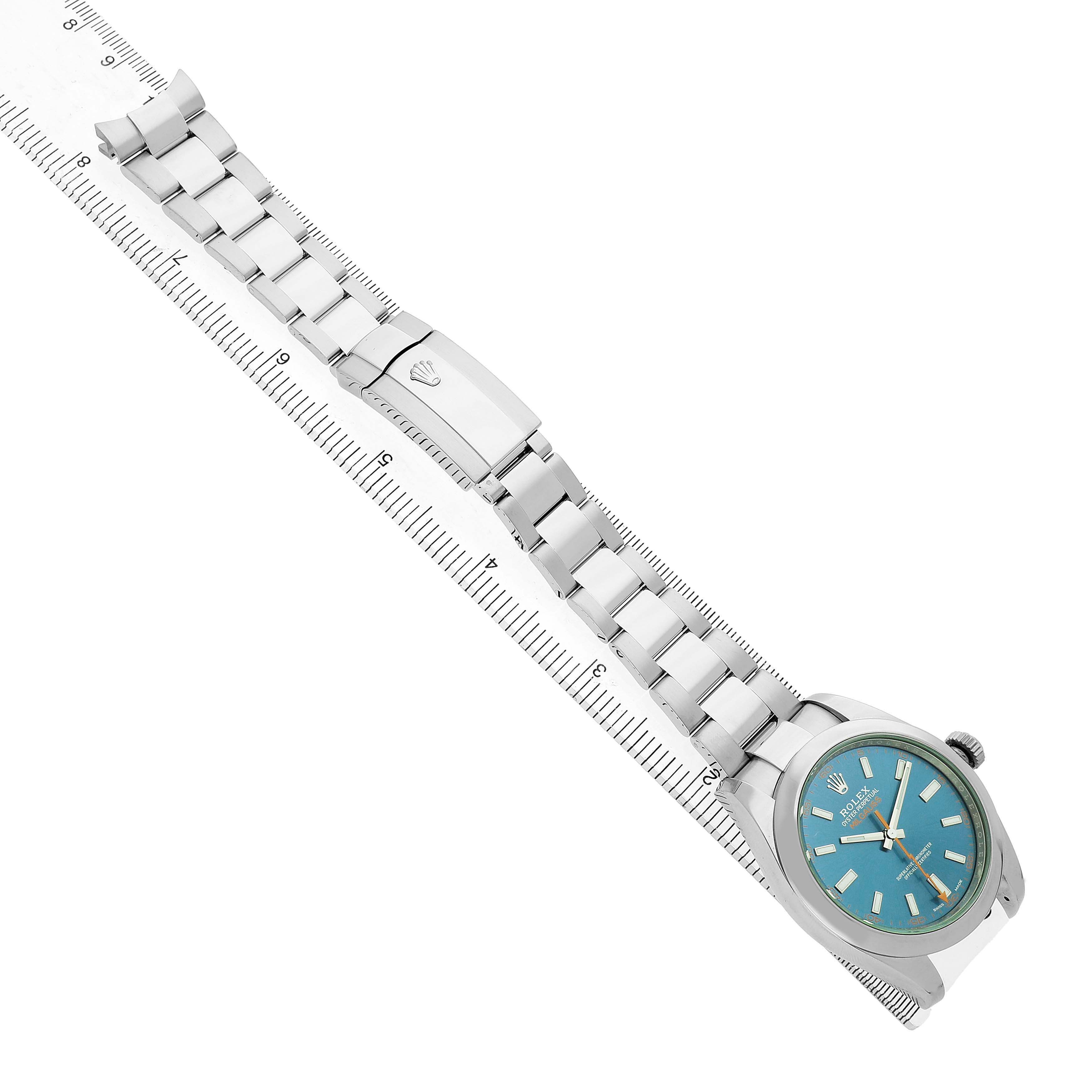 The image shows a Rolex Milgauss M116400GV Men's Stainless Steel Blue Dial watch from a top-down angle, highlighting the bracelet and clasp on a ruler.