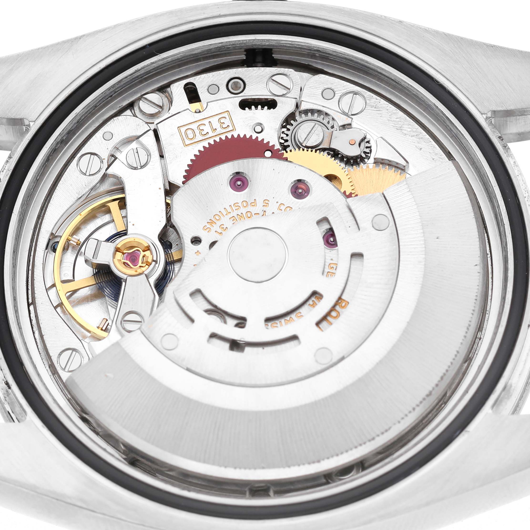 The image shows the movement of a Rolex Oyster Perpetual 116000 Men's Stainless Steel Silver Dial watch from the back, highlighting gears and mechanical components.