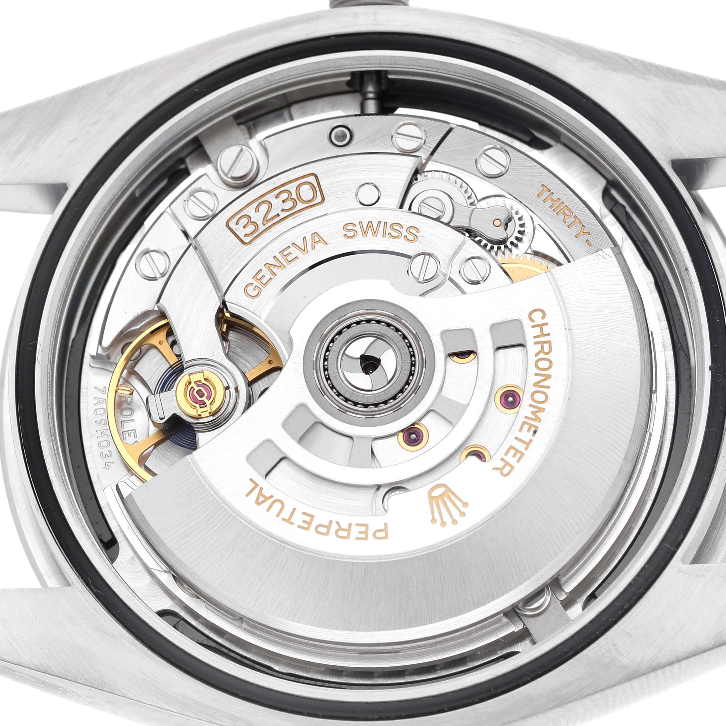 The image shows the movement of a Rolex Oyster Perpetual M124300-0002 Men's Stainless Steel Black Dial watch from the back, highlighting its intricate mechanical components.