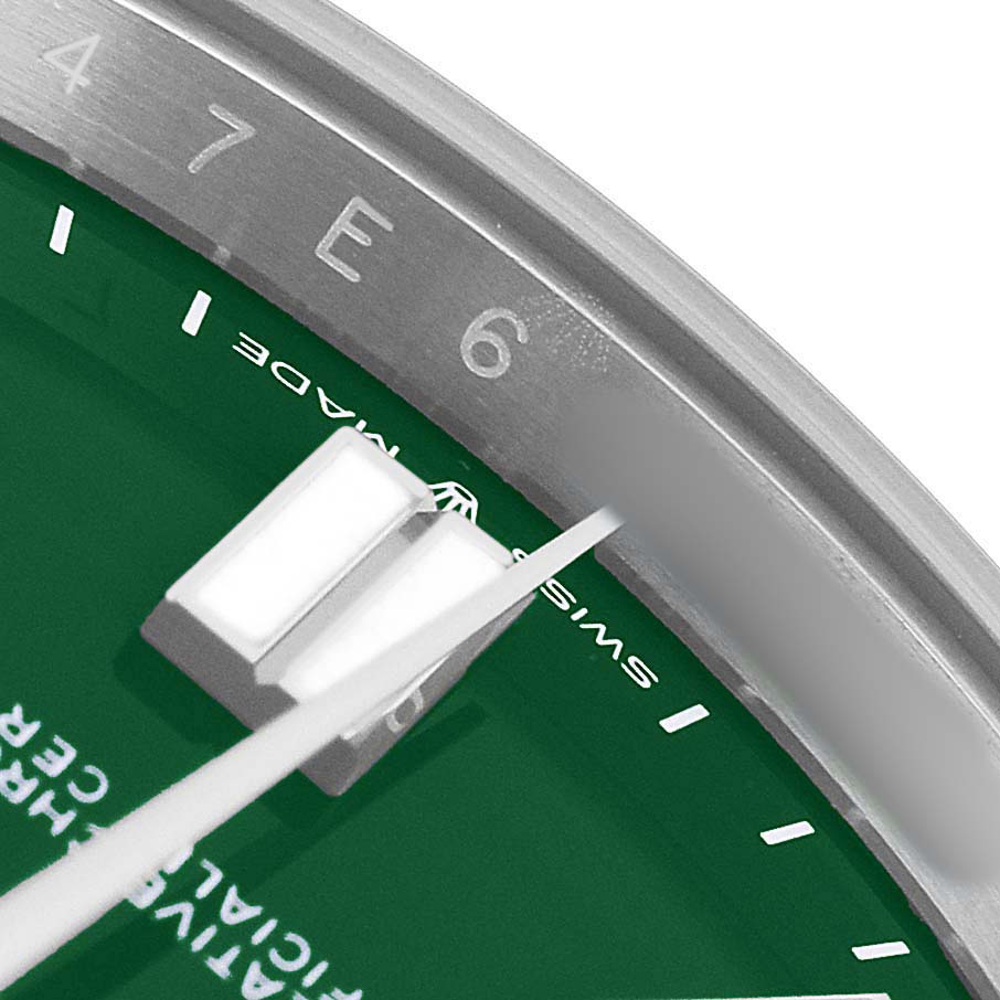 The image shows a close-up of the dial and bezel of a Rolex Oyster Perpetual M124300-0005 Men's Stainless Steel Green Dial watch, focusing on the indices and hands.