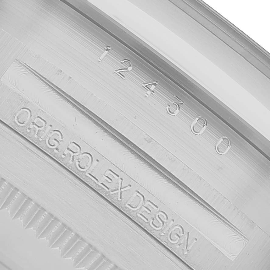 The image shows the engraved details on the inner bezel of a Rolex Oyster Perpetual M124300-0005 Men's Stainless Steel Green Dial watch, displaying serial and design numbers.