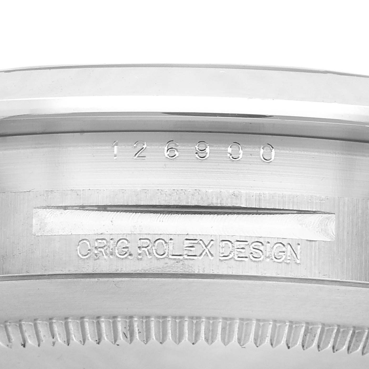 The image shows a close-up of the Rolex Air-King 126900 Men's Stainless Steel Black Dial 126900 Men's Stainless Steel Black Dial's engraved case edge, displaying the model number and "ORIG. ROLEX DESIGN" text.