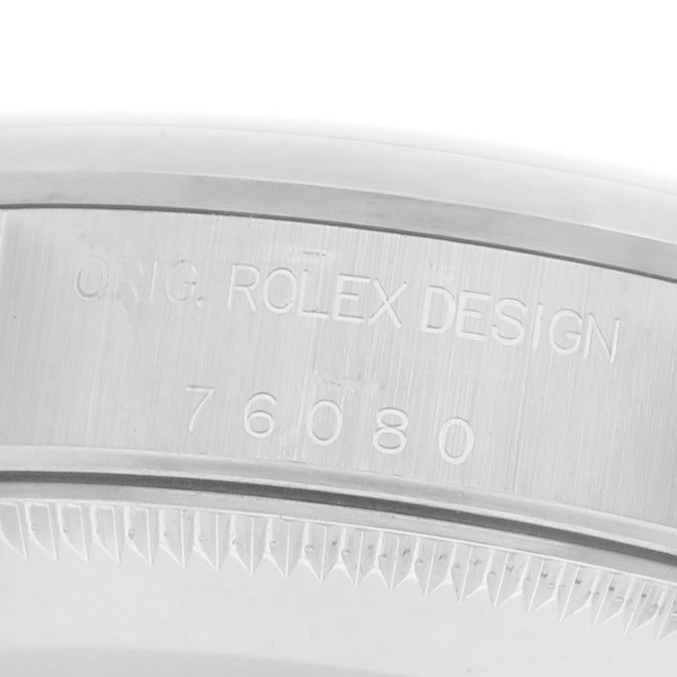The image shows a close-up angle of the case back engraving on a Rolex Oyster Perpetual 72105 Women's Stainless Steel Pink Dial 72105 Women's Stainless Steel Pink Dial, featuring text and serial number.