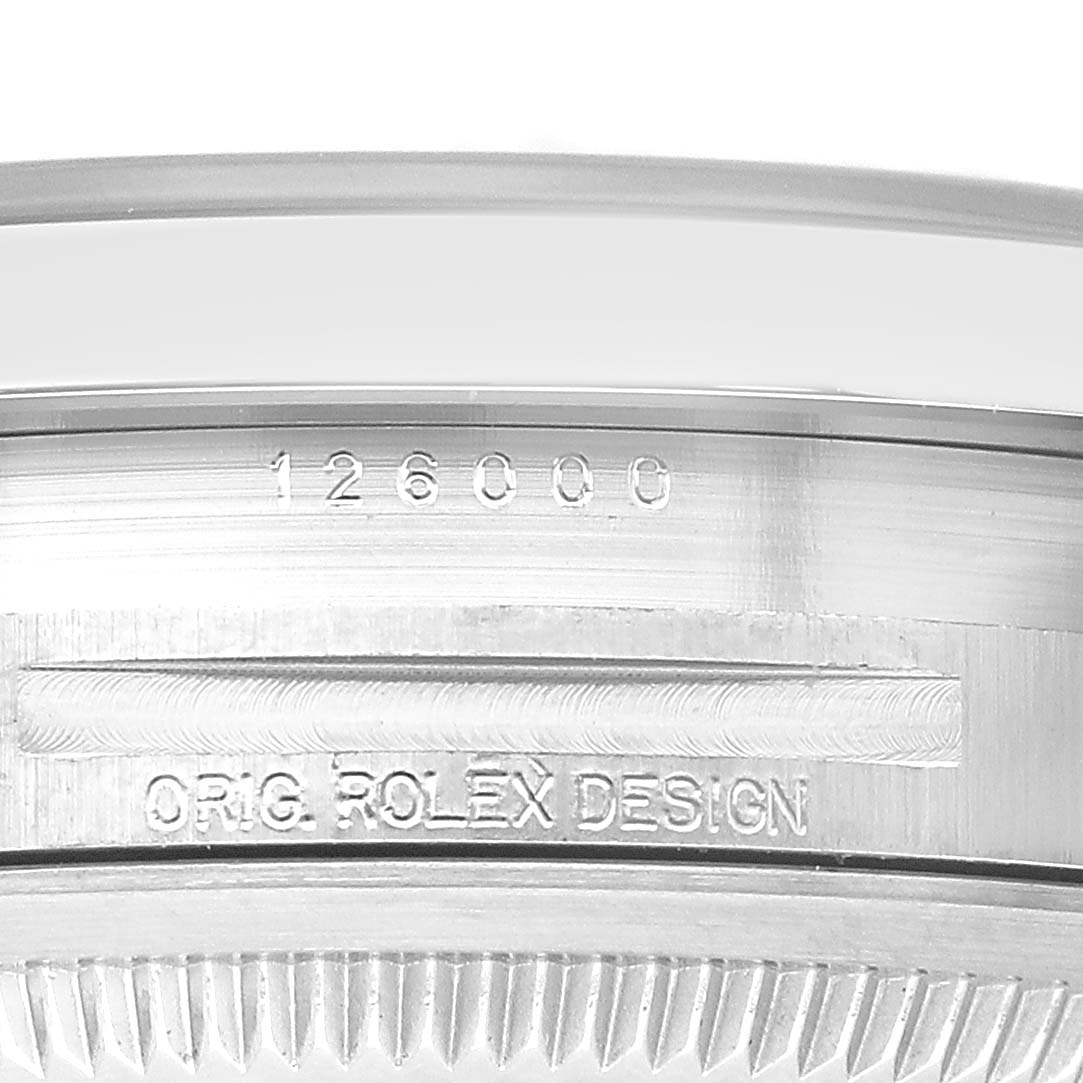 The image shows a close-up of the case side and bezel of the Rolex Oyster Perpetual 126000 Men's Stainless Steel Black Dial, highlighting the "ORIG. ROLEX DESIGN" engraving.