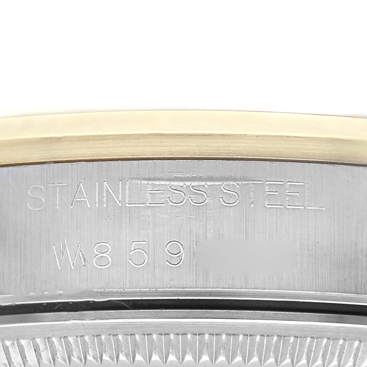 The image shows a close-up of the case side with the engraved "STAINLESS STEEL" marking on a Rolex Oyster Perpetual 14203 Men
s Steel and Gold (two tone) Champagne Dial 14203 Men
s Steel and Gold (two tone) Champagne Dial watch.