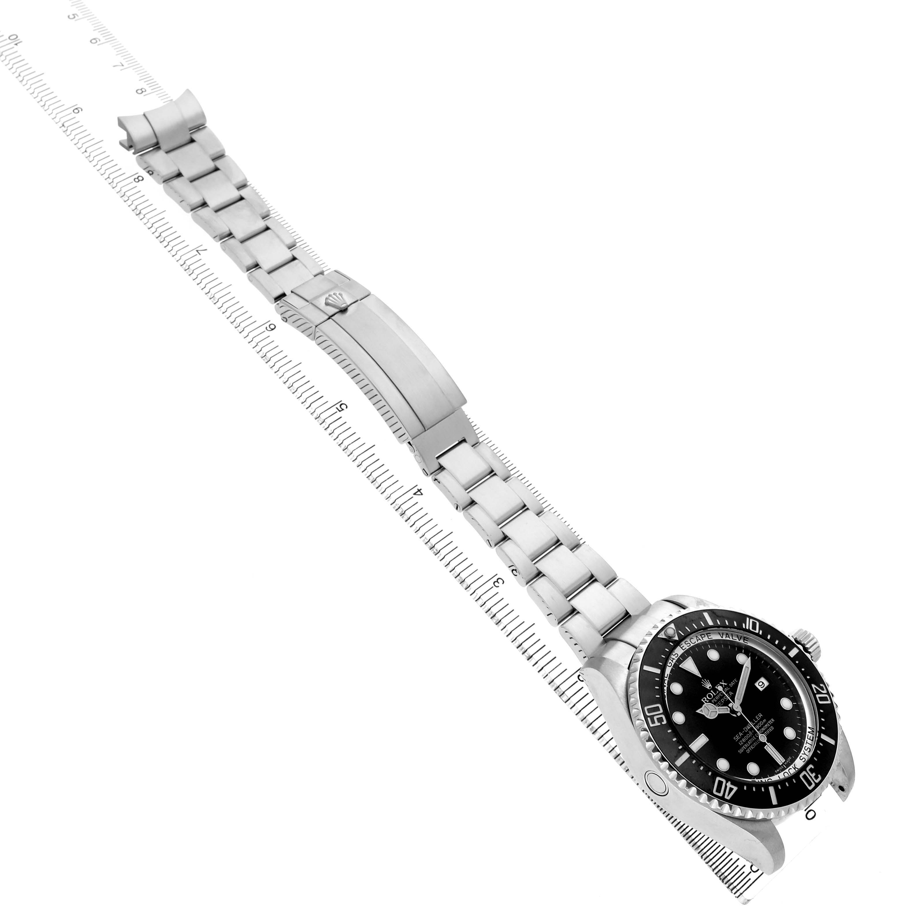 The image shows a Rolex Sea-Dweller 116660 Men's Stainless Steel Black Dial watch at an oblique angle, highlighting the face, bezel, and bracelet on a ruler.