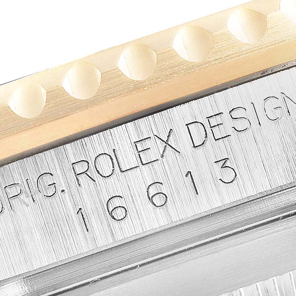 This close-up image of the Rolex Submariner 16613 Men
s Steel and Gold (two tone) Blue Dial 16613 Men
s Steel and Gold (two tone) Blue Dial watch displays the reference number and part of the bezel.