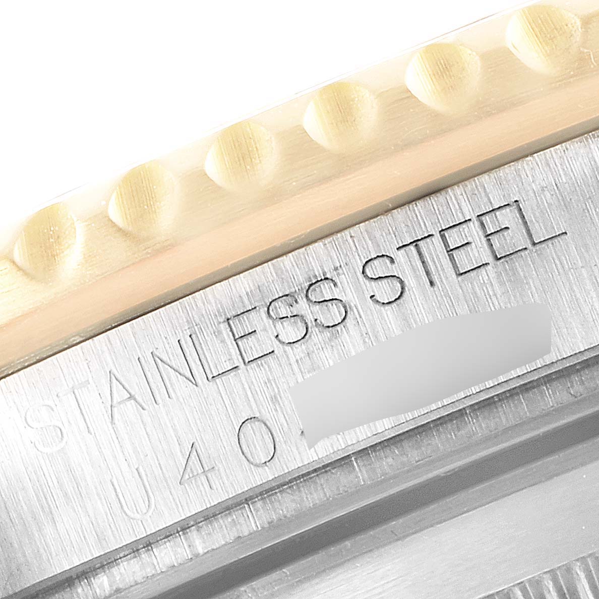 This close-up image shows the edge of the bezel and the back case engraving of a Rolex Submariner 16613 Men
s Steel and Gold (two tone) Blue Dial 16613 Men
s Steel and Gold (two tone) Blue Dial watch.