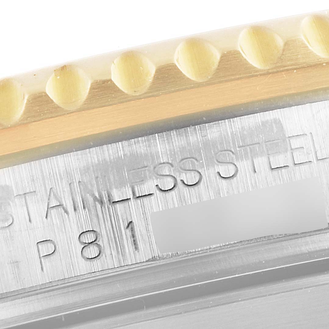 The image shows a close-up of the stainless steel edge and bezel of a Rolex Submariner 16613 Men
s Steel and Gold (two tone) Blue Dial 16613 Men
s Steel and Gold (two tone) Blue Dial watch, with some engraved text visible.