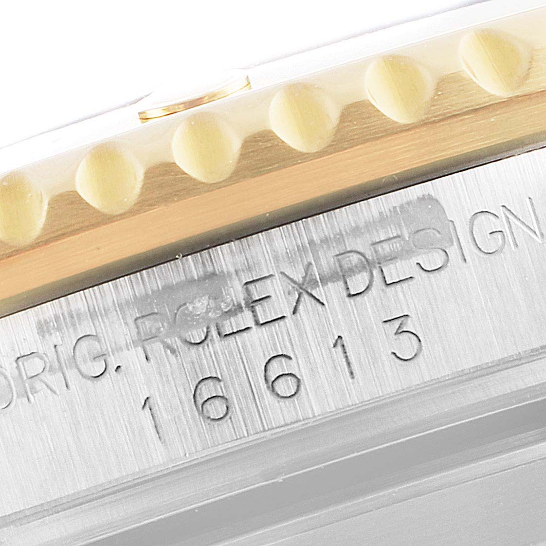This close-up angle shows the edge of the bezel and the engraved model number on the case of a Rolex Submariner 16613 Men
s Steel and Gold (two tone) Blue Dial 16613 Men
s Steel and Gold (two tone) Blue Dial.