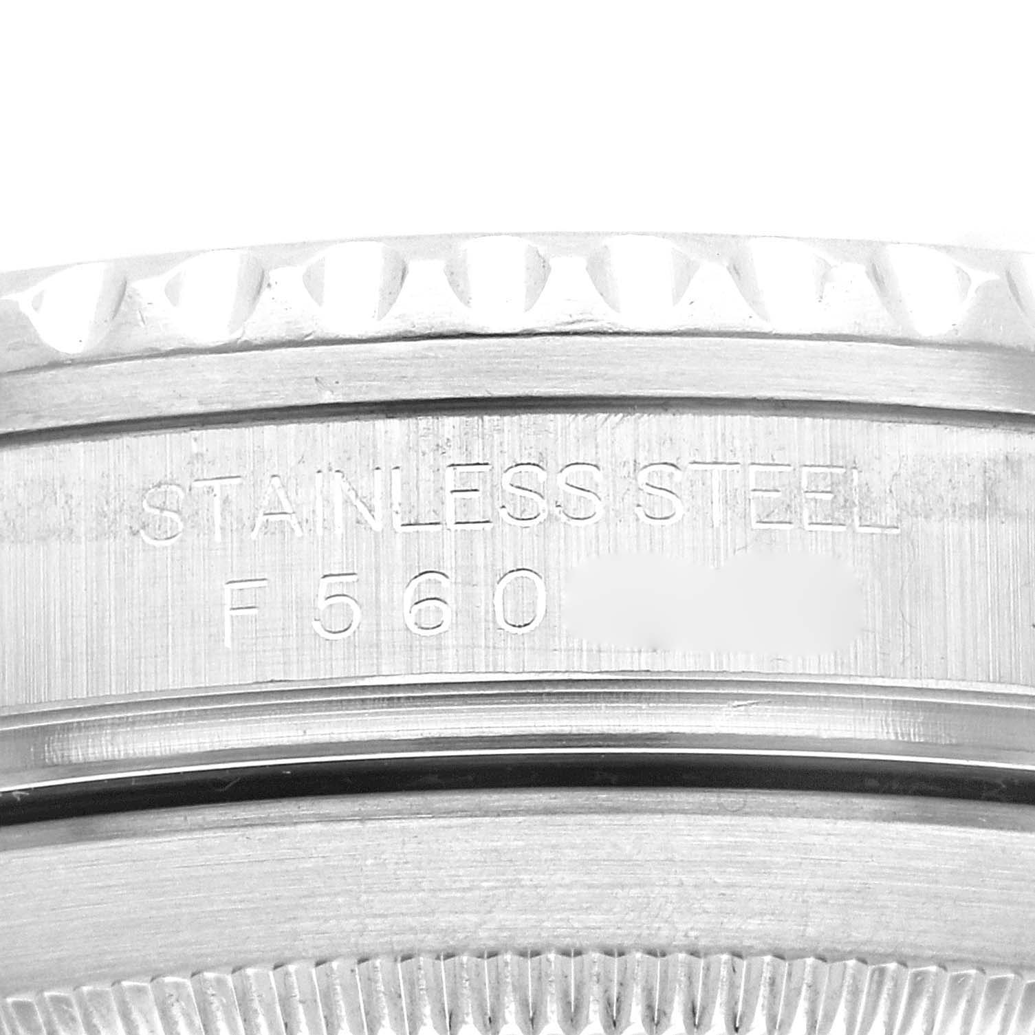 The image shows a close-up of the side of a Rolex Submariner 16610 Men
s Stainless Steel Black Dial 16610 Men
s Stainless Steel Black Dial watch case, highlighting the stainless steel marking and partial serial number.