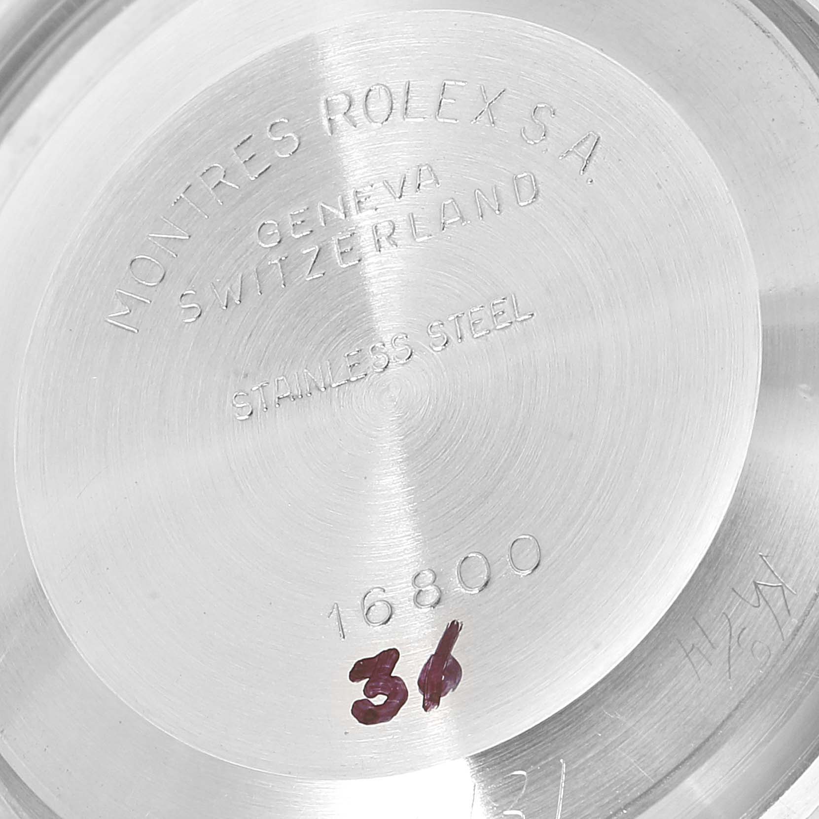 This image shows the case back of a Rolex Submariner 16800 Men
s Stainless Steel Black Dial 16800 Men
s Stainless Steel Black Dial model 16800, etched with text indicating "Montres Rolex S.A. Geneva Switzerland" and "Stainless Steel".