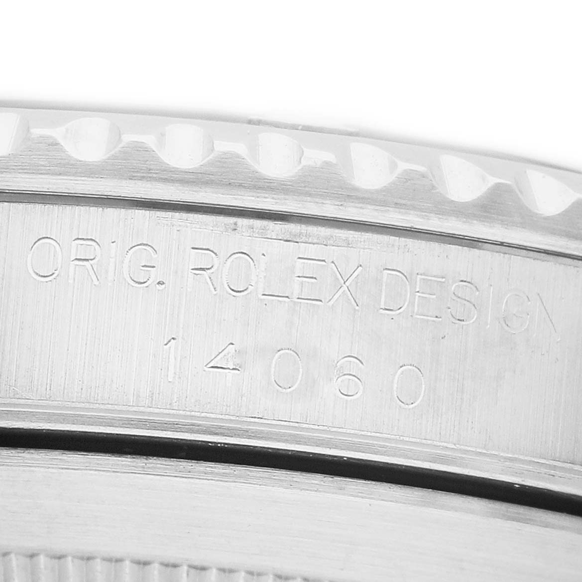 The image shows a close-up of the side of a Rolex Submariner 14060M Men's Stainless Steel Black Dial watch case with engraved design details.