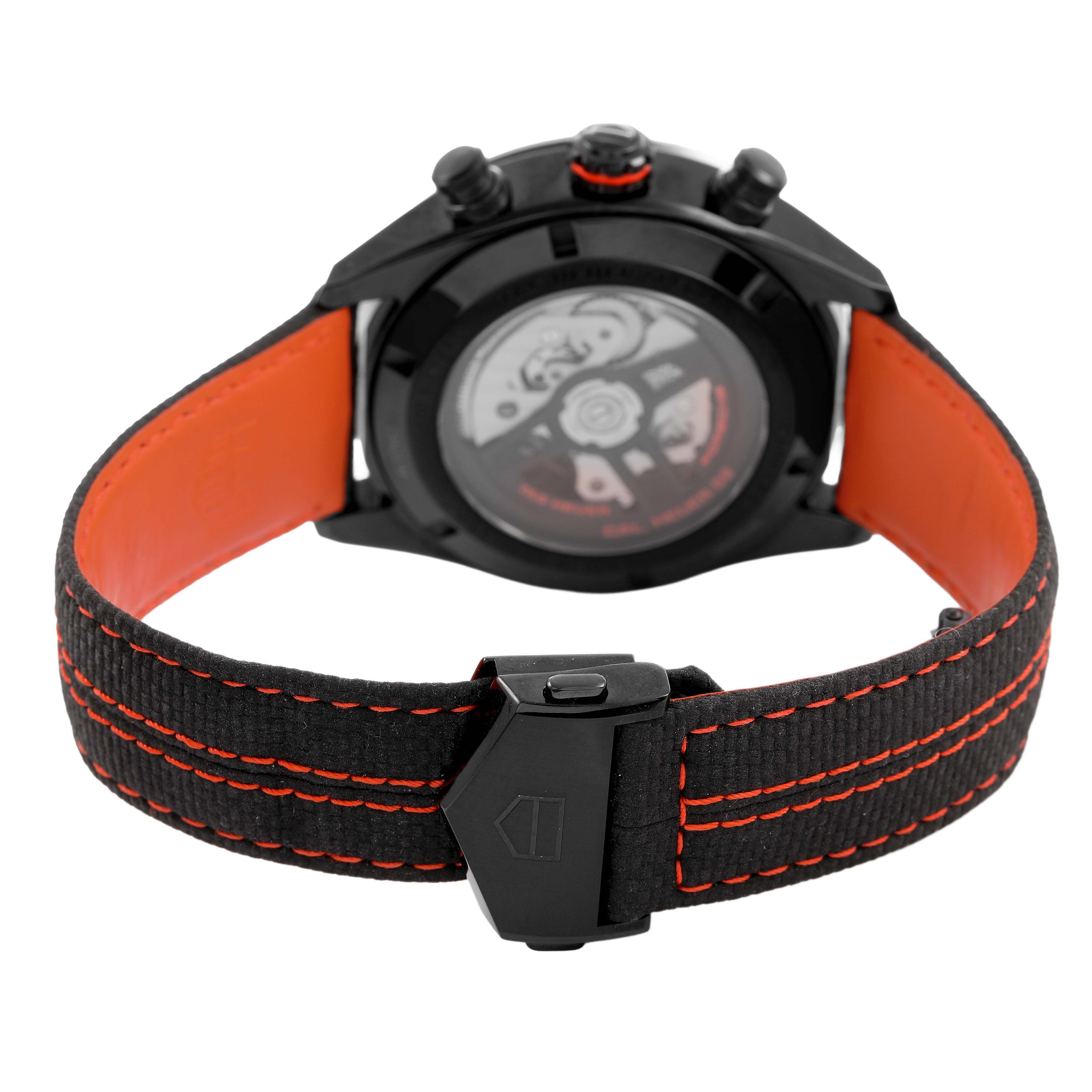 The image shows the back of a Tag Heuer Carrera CBN2A1M.FC6526 Men's Stainless Steel Black Dial watch, highlighting the black case, visible movement, and red-stitched strap.