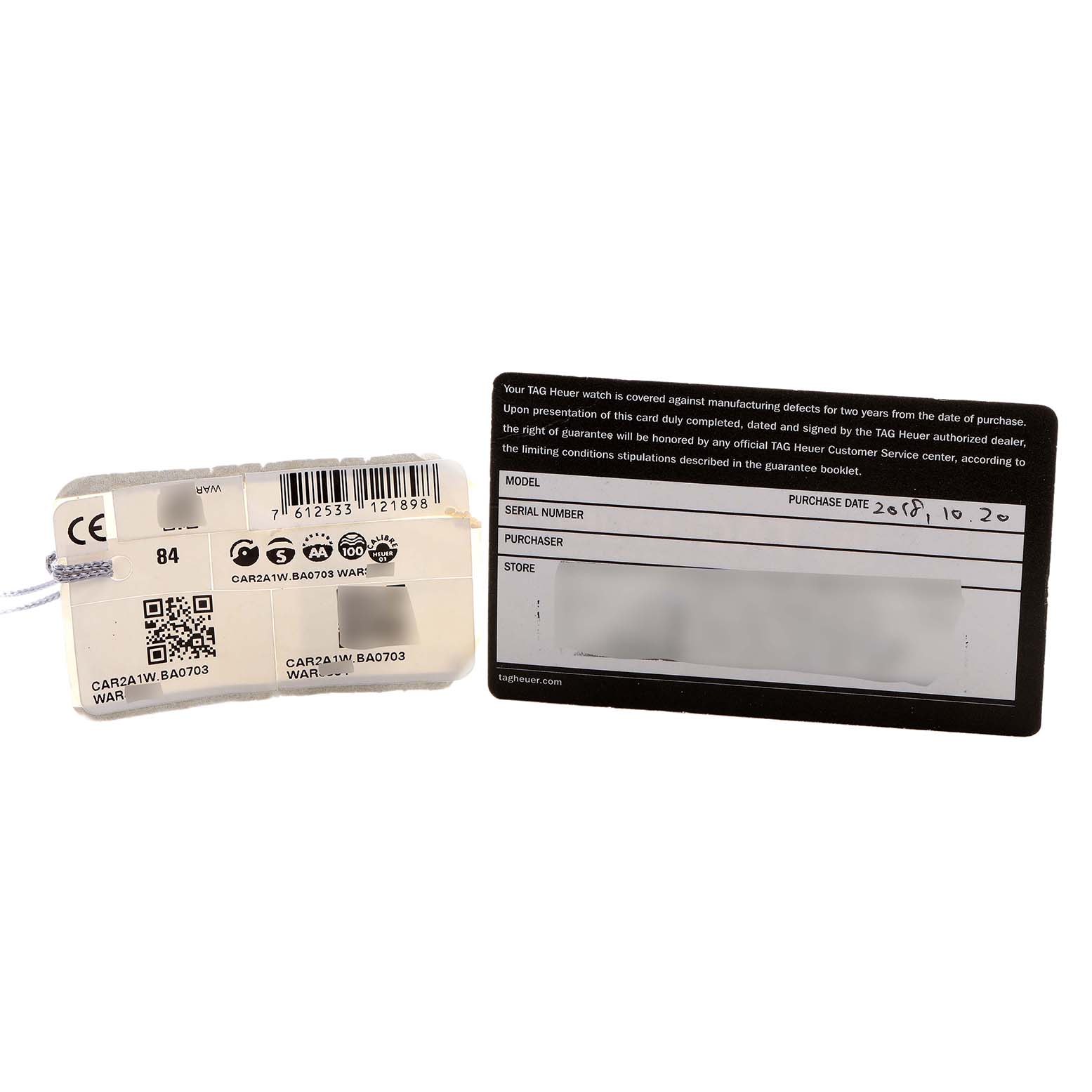 The image shows a warranty card and a tag for the Tag Heuer Carrera CAR2A1W.BA0703 Men's Stainless Steel Transparent Dial model, viewed from above.