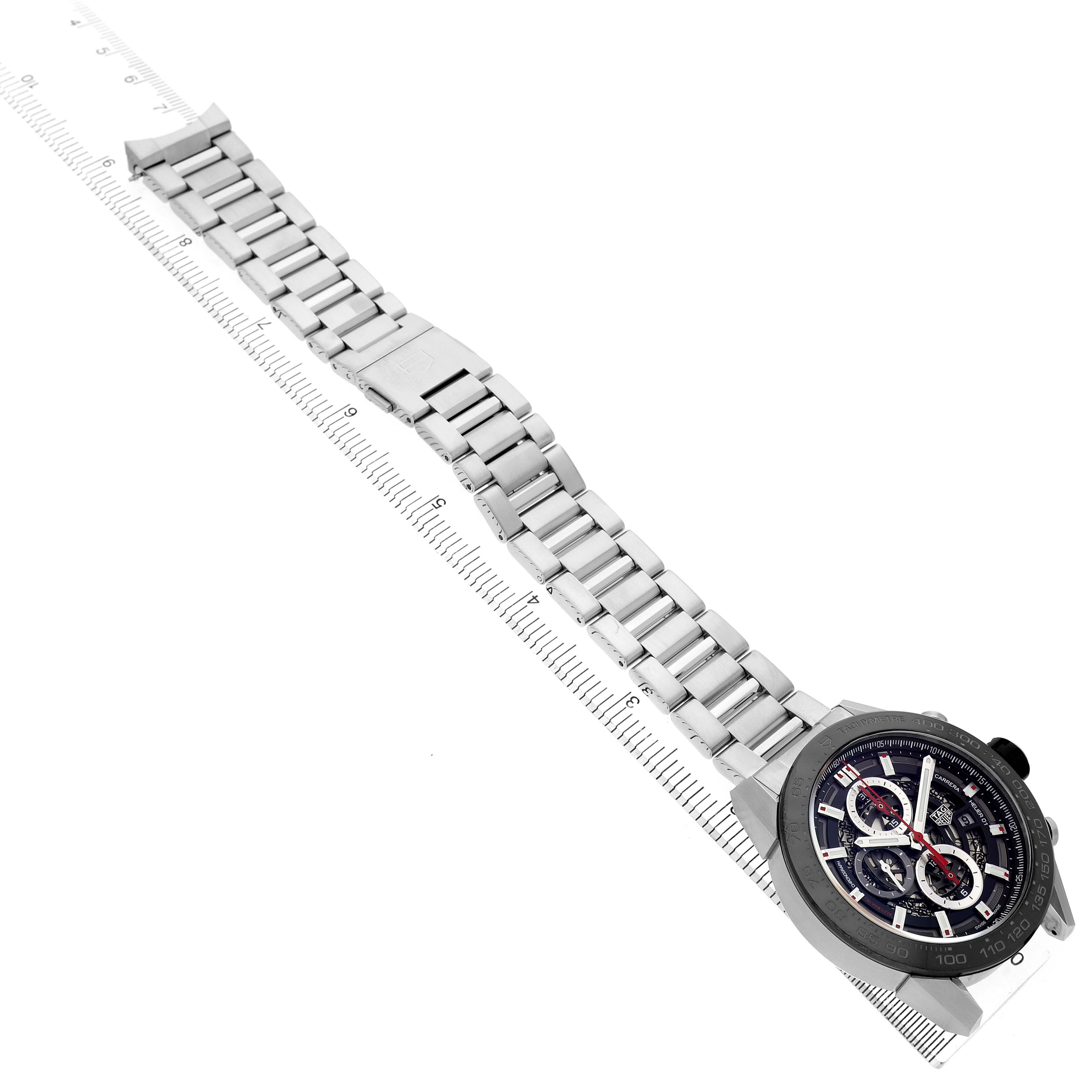 The Tag Heuer Carrera CAR2A1W.BA0703 Men's Stainless Steel Transparent Dial watch is shown from an angled top view, displaying its bracelet and face on a ruler for measurement.